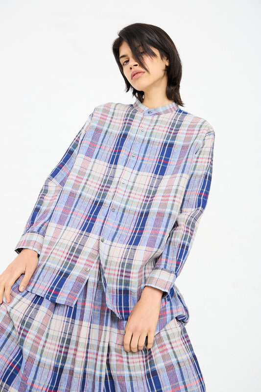 A person with short dark hair is wearing the Ichi Antiquités Linen Check Shirt in Navy and a matching pleated skirt, posing against a plain white background.