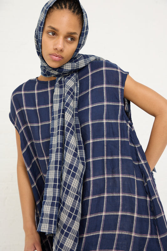 Woman wearing a linen check stole in dark indigo and natural from Ichi Antiquités, with a hood, posing for the camera.