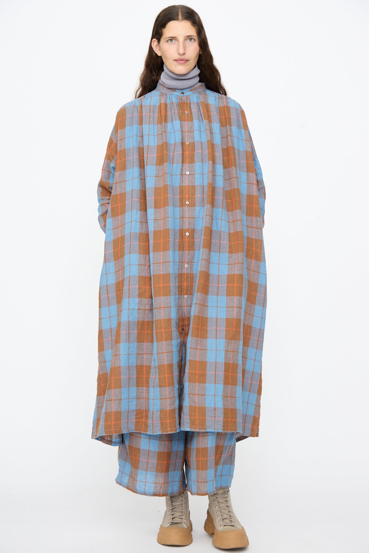 A person wearing an Ichi Antiquités Linen Cotton Check Dress in Blue over matching wide-leg pants and tan boots.