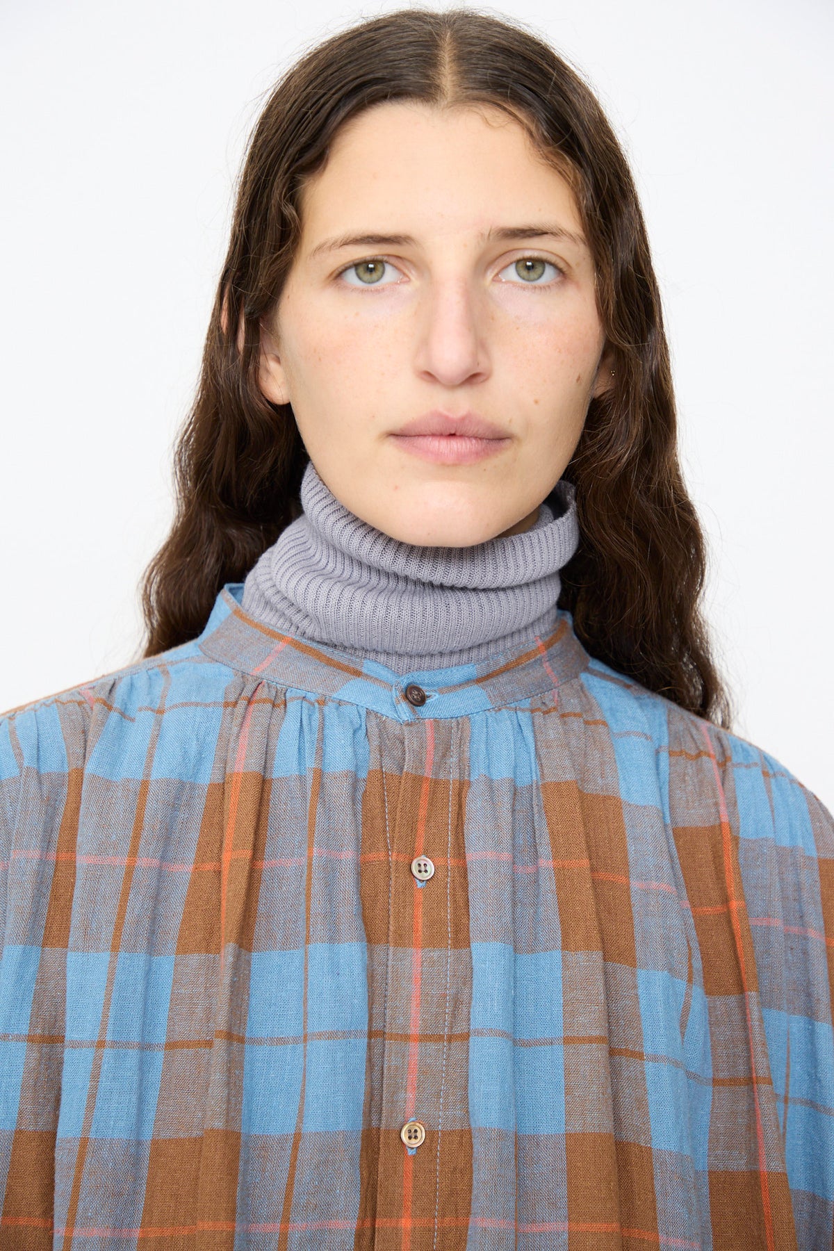 A person wearing an Ichi Antiquités Linen Cotton Check Dress in Blue layered over a grey turtleneck sweater.