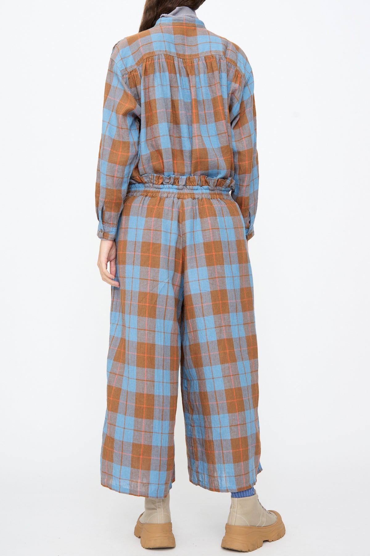 Back view of a person wearing a matching shirt and Ichi Antiquités Linen Cotton Check Pants in Blue, paired with beige lug-sole boots.