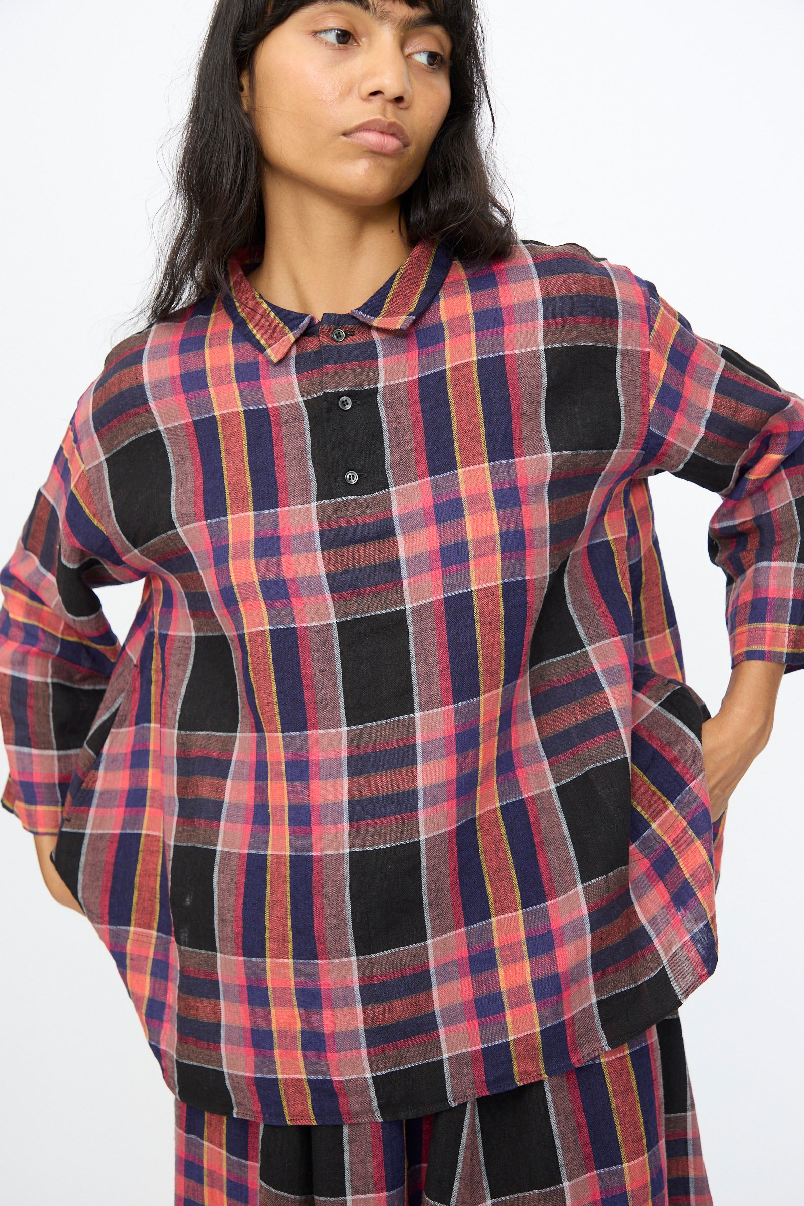 Someone stands against a plain light background wearing the Ichi Antiquités Linen Cotton Check Shirt in Black—a loose-fitting, long-sleeve linen cotton plaid shirt.