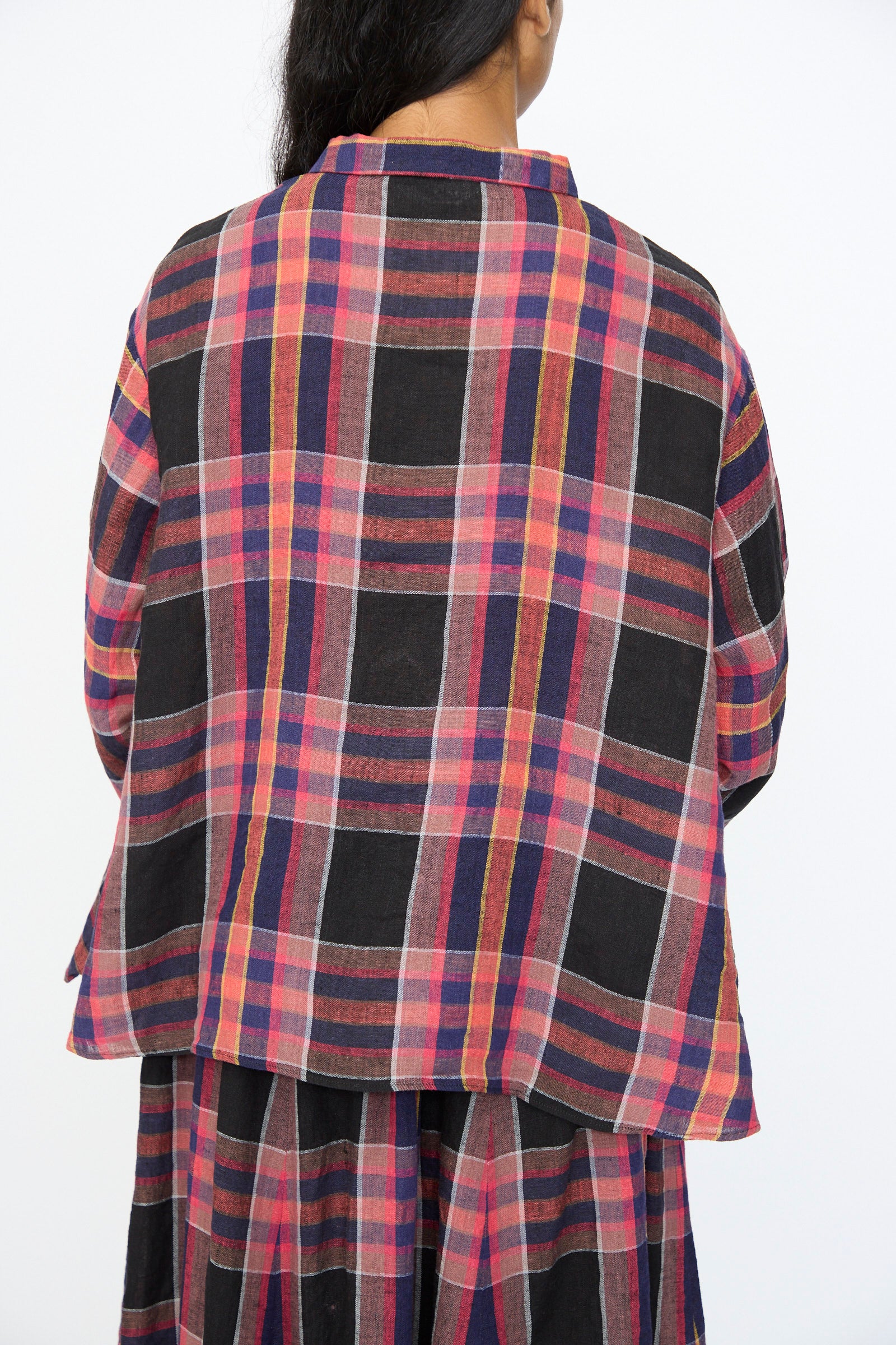 A person with long dark hair is seen from the back, wearing the Ichi Antiquités Linen Cotton Check Shirt in Black, styled against a plain background.