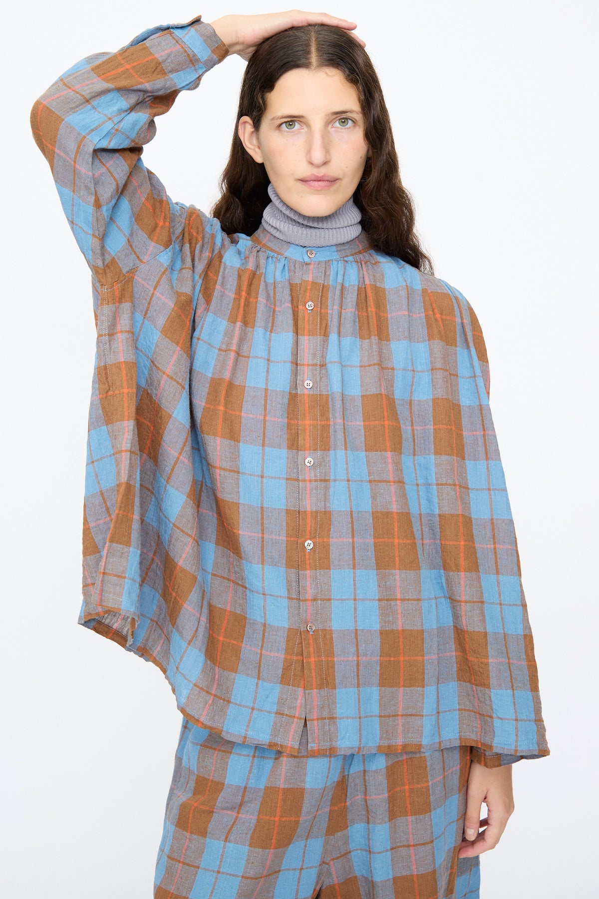 A person wearing an Ichi Antiquités Linen Cotton Check Shirt in Blue over a grey mock-neck top.
