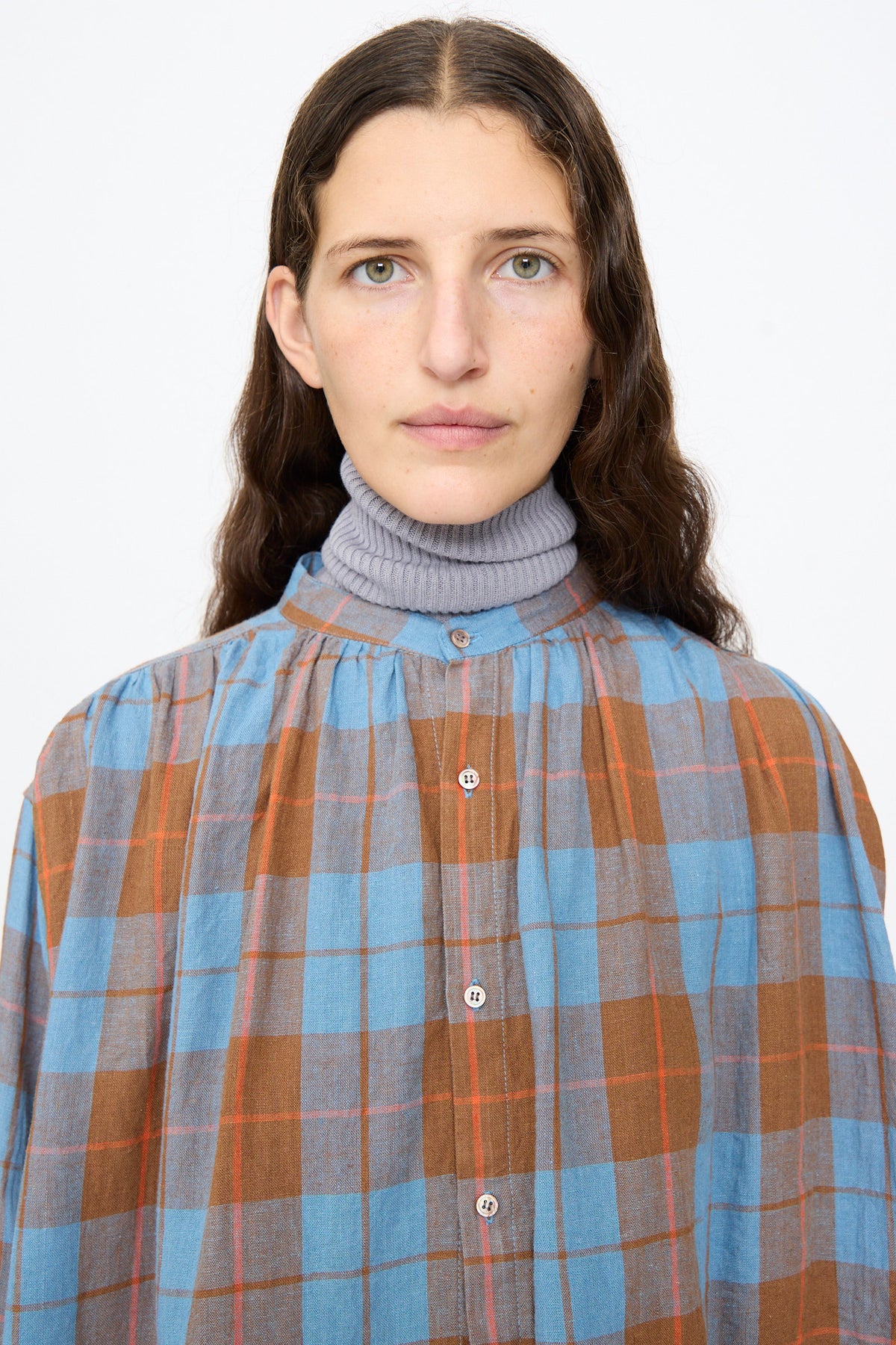 A person wearing an Ichi Antiquités Linen Cotton Check Shirt in Blue over a grey turtleneck.