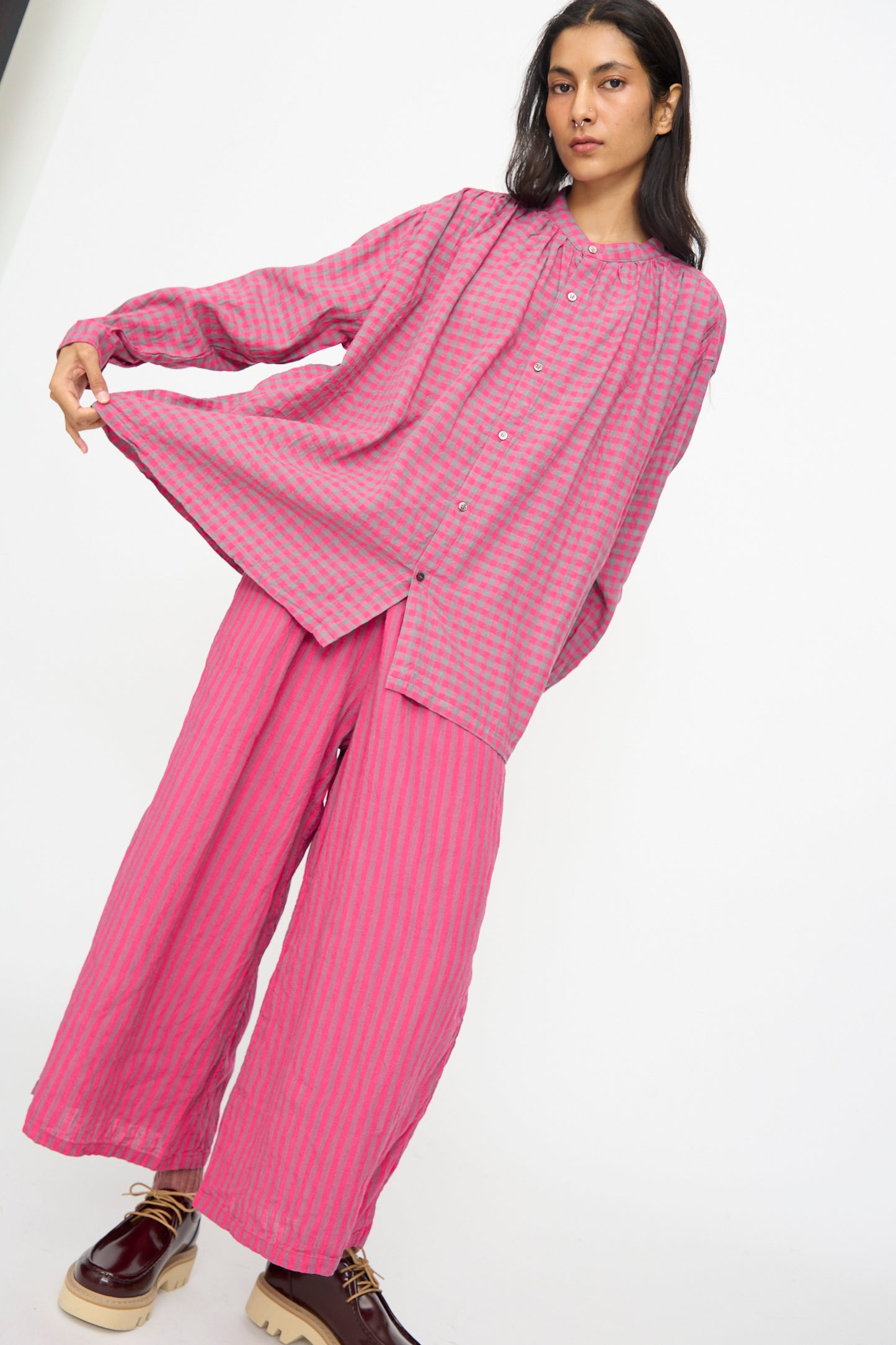 A person wears the Ichi Antiquités Linen Cotton Gingham Check Shirt in Pink, a loose-fitting button-up, paired with matching wide-leg pants against a plain white background.