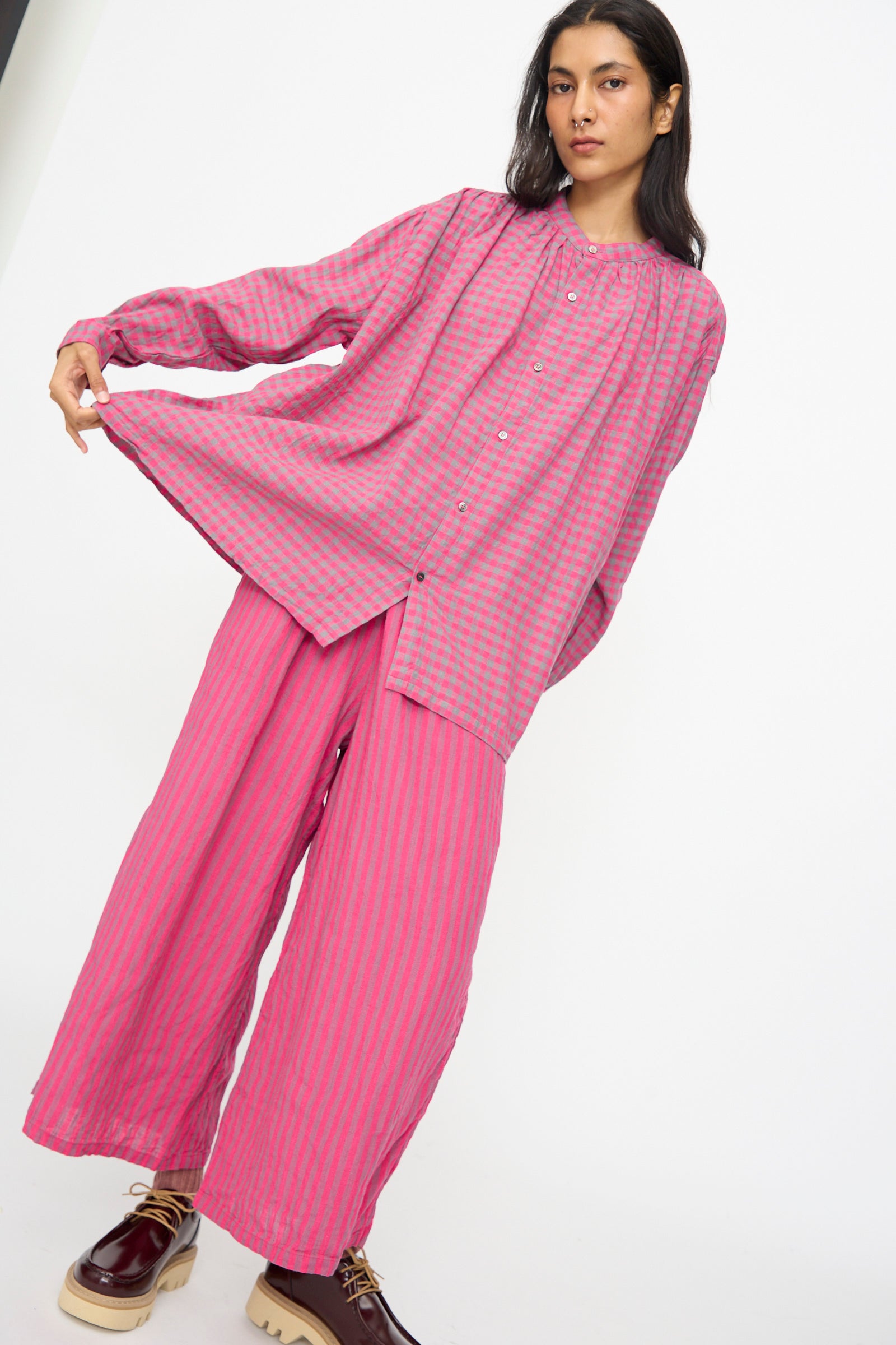 A person wears the Ichi Antiquités Linen Cotton Gingham Check Shirt in Pink, a loose-fitting button-up, paired with matching wide-leg pants against a plain white background.
