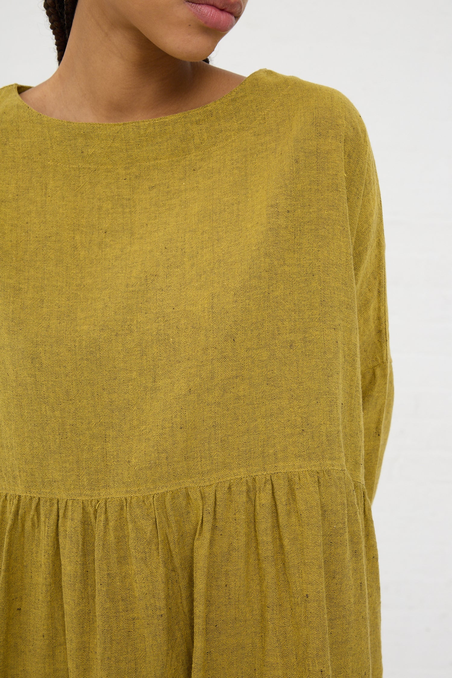 Close-up of a person wearing an Ichi Antiquités Linen Cotton Herringbone Dress in Yellow with a round neckline.