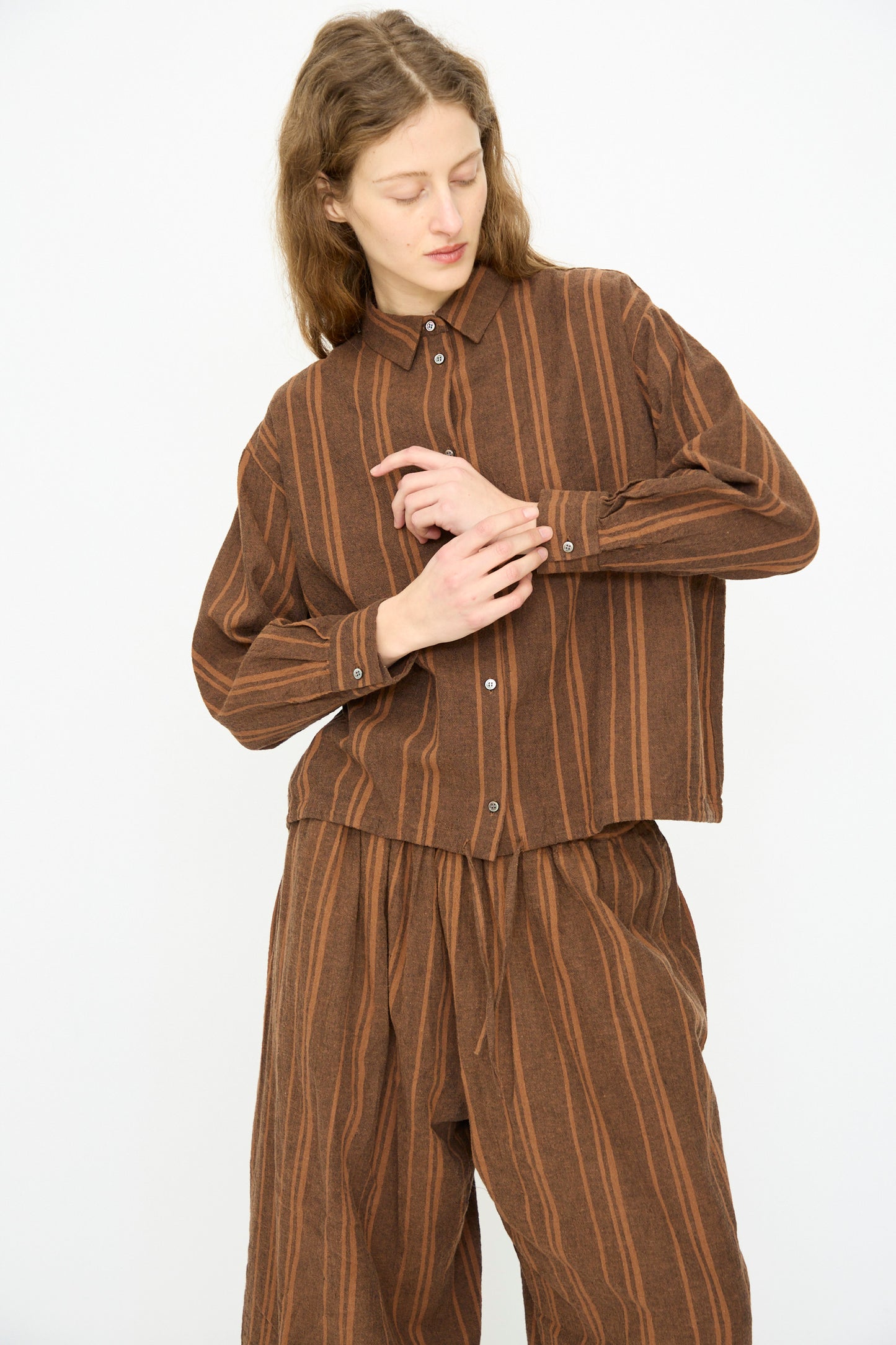 A person wears the Ichi Antiquités Linen Cotton Random Stripe Shirt in Brown with matching wide-leg pants, made in Japan, standing against a plain white background.