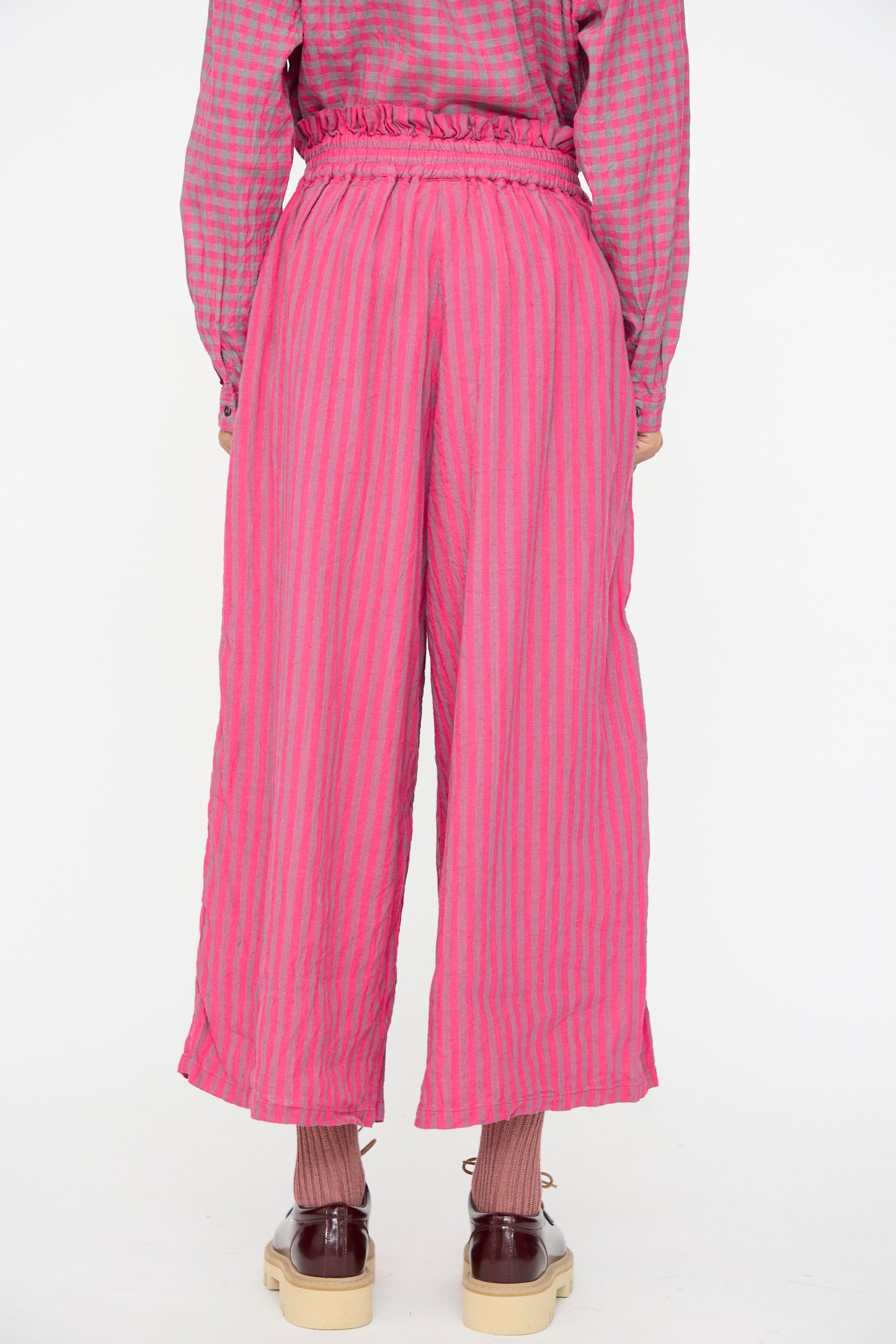 A person is shown from the back wearing Ichi Antiquités Linen Cotton Stripe Pants in Pink, paired with a matching checkered top, pink socks, and brown shoes.