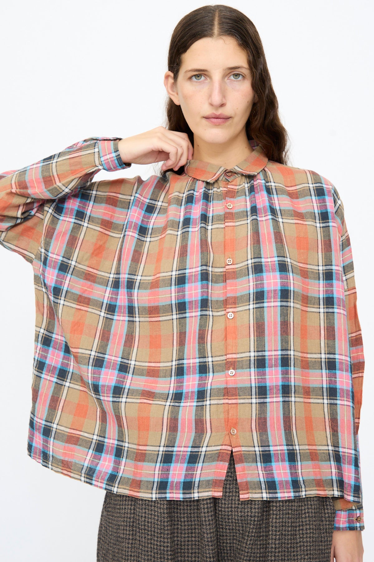 A person wearing an Ichi Antiquités Linen Cotton Tartan Check Shirt in Beige, featuring a made-in-Japan beige, red, and blue tartan pattern with a rounded collar and button-down front.