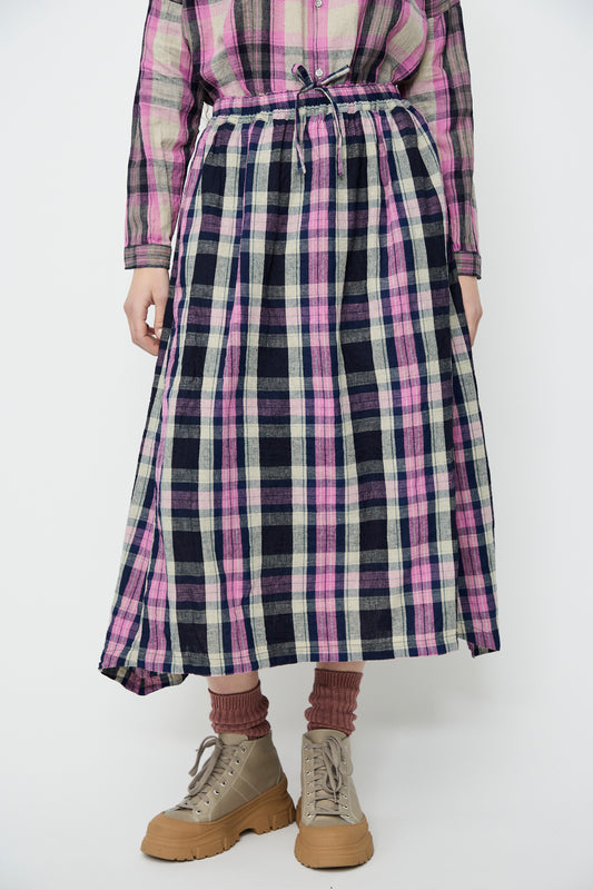 A person is wearing the Linen Cotton Tartan Skirt in Indigo by Ichi Antiquités, styled with beige high-top shoes against a white background.