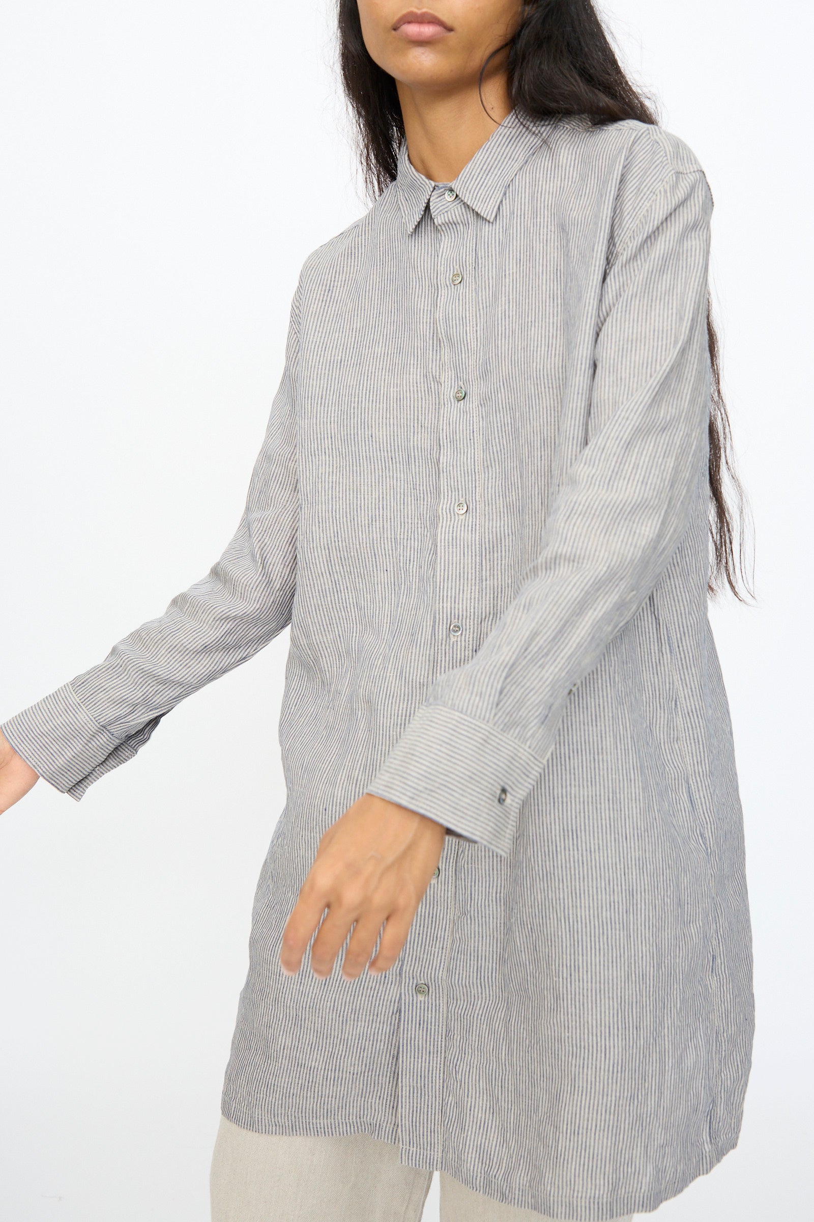A person wears the Ichi Antiquités Linen Dungaree Shirt in Stripe with beige pants, standing against a plain white background.