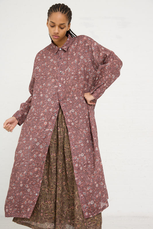 A person wearing an oversized floral pattern linen coat over a Linen Floral Dress in Pink by Ichi Antiquités against a plain background.