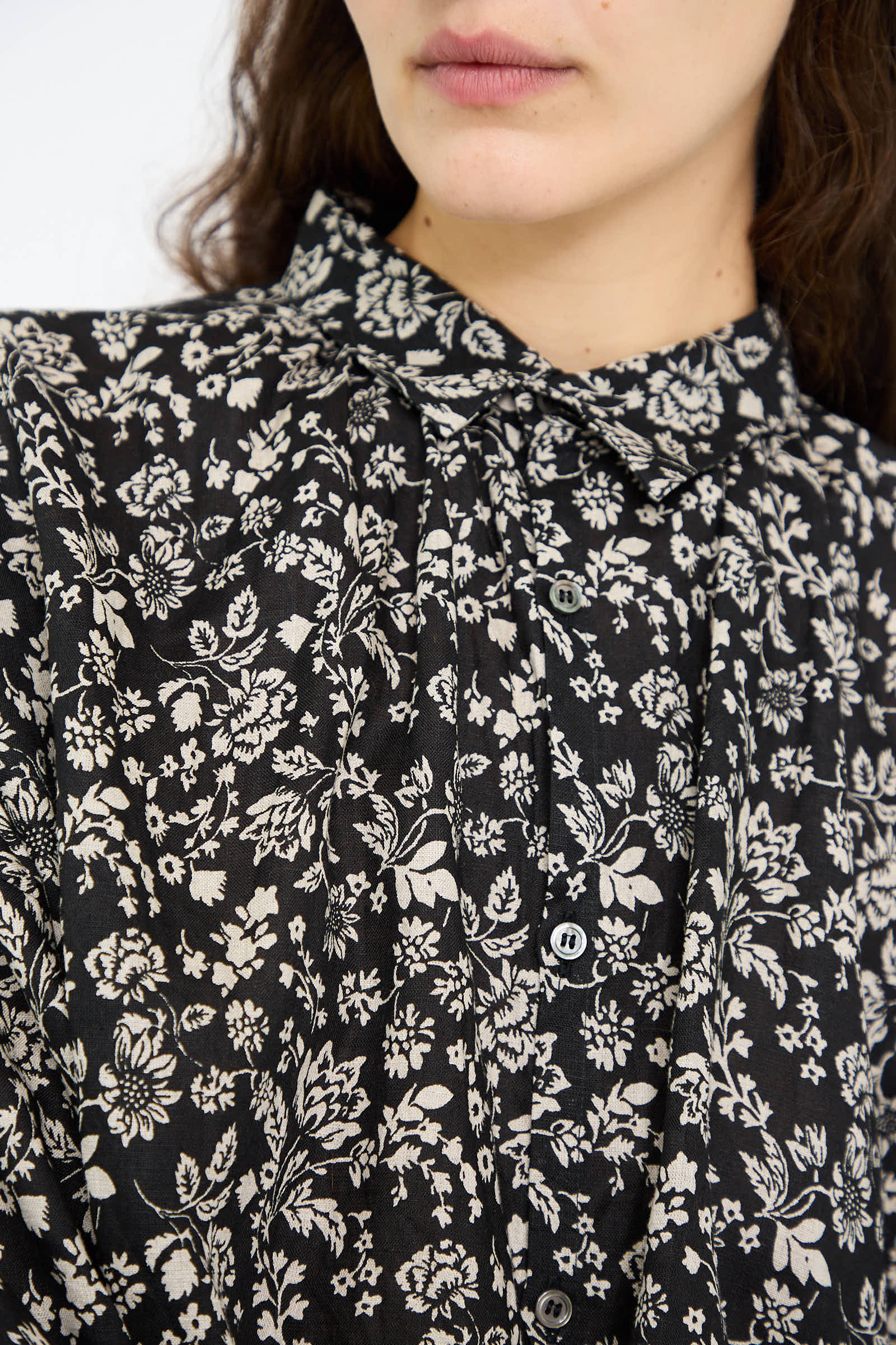 Close-up of a person wearing the Linen Flower Print Shirt in Black by Ichi Antiquités, featuring button detailing.