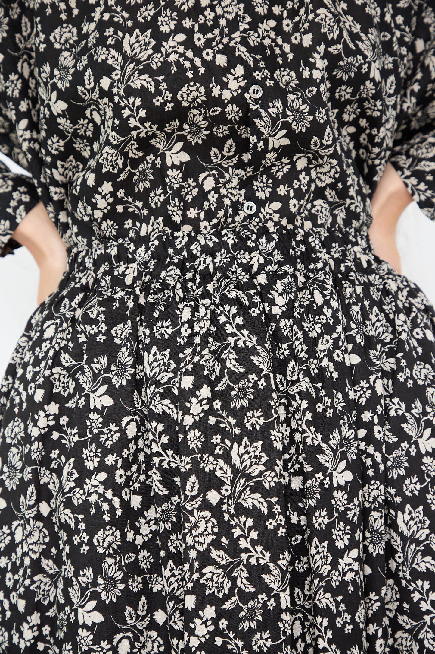 Close-up of the Linen Flower Print Skirt in Black by Ichi Antiquités, showcasing a white linen flower pattern with buttons and an elasticated, cinched waist.