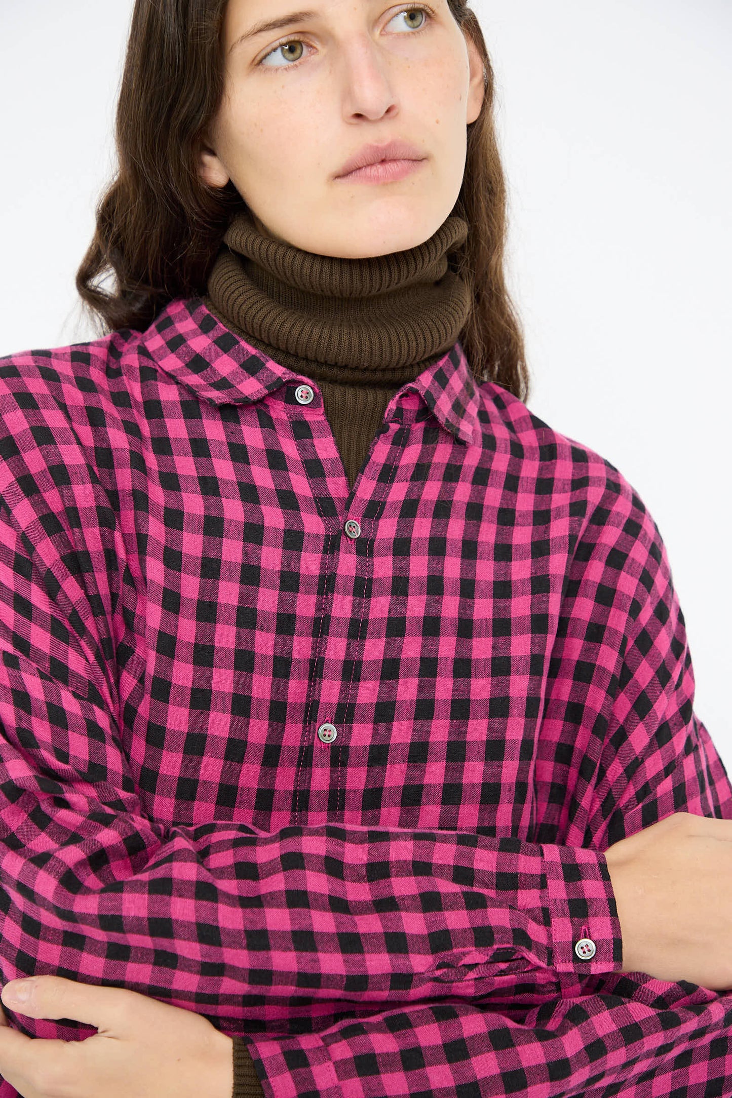 A person wearing the Linen Gingham Check Dress in Pink by Ichi Antiquités over a brown turtleneck.