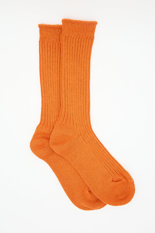 A pair of bright orange Linen Rib Socks by Ichi Antiquités against a white background.