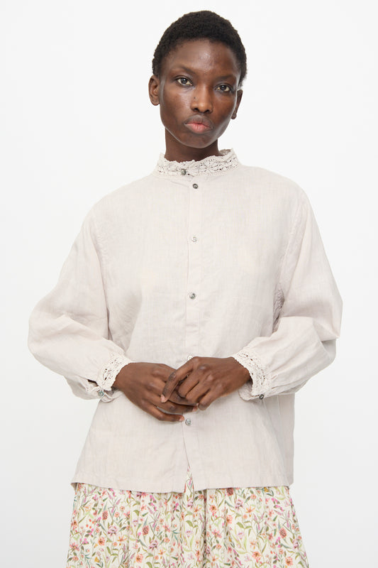 A person wears the Ichi Antiquités Linen Shirt in Greige—an oversized, light-colored linen top with lace collar and cuffs—paired with a floral skirt, standing against a plain white background.