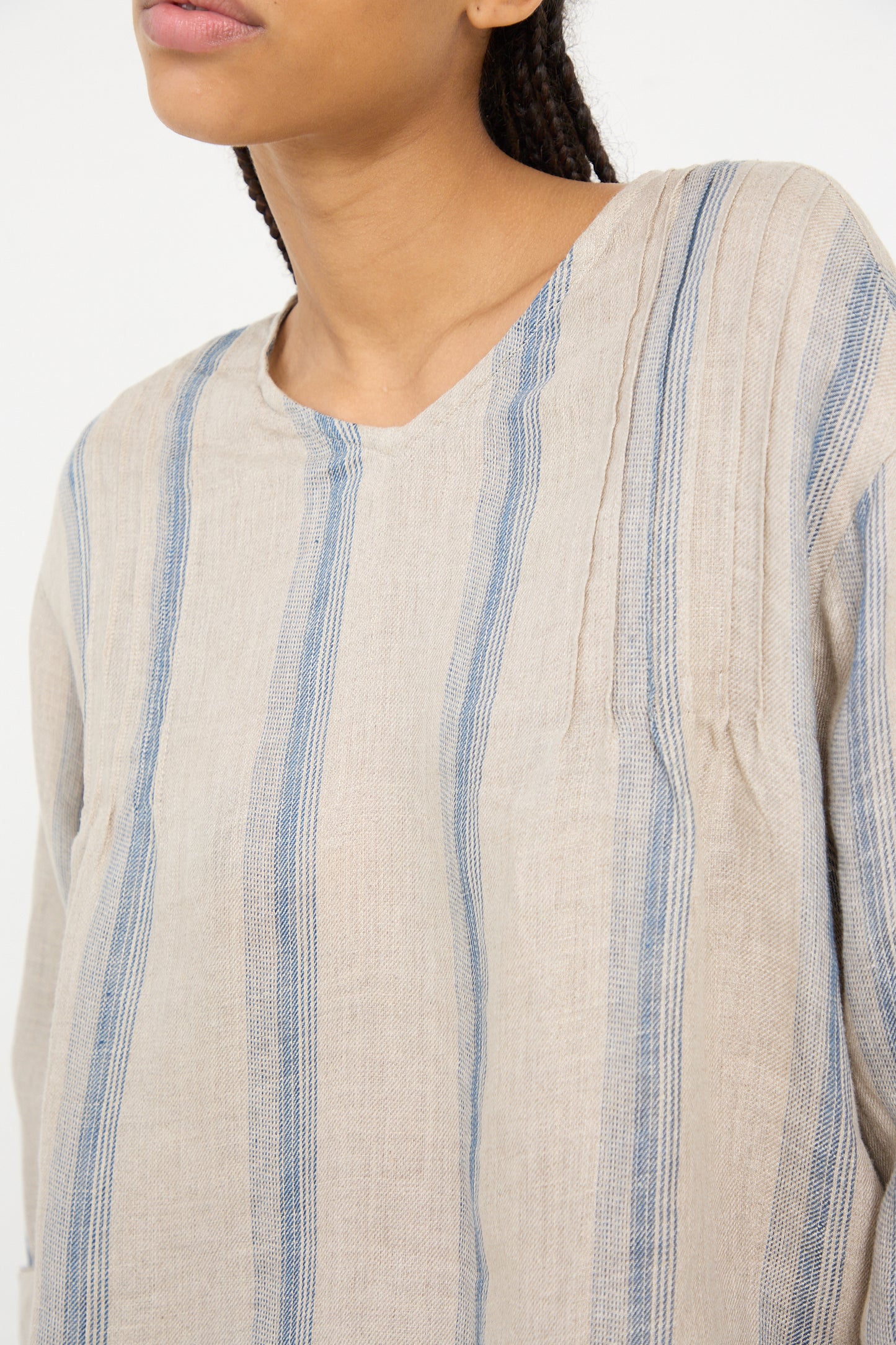 Close-up of a person wearing an oversized beige striped Linen Stripe Pullover in Natural and Indigo from Ichi Antiquités.