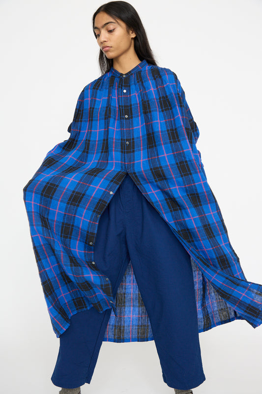 A model wearing the Ichi Antiquités Linen Tartan Dress in Blue stands against a plain background, complemented by matching blue pants.