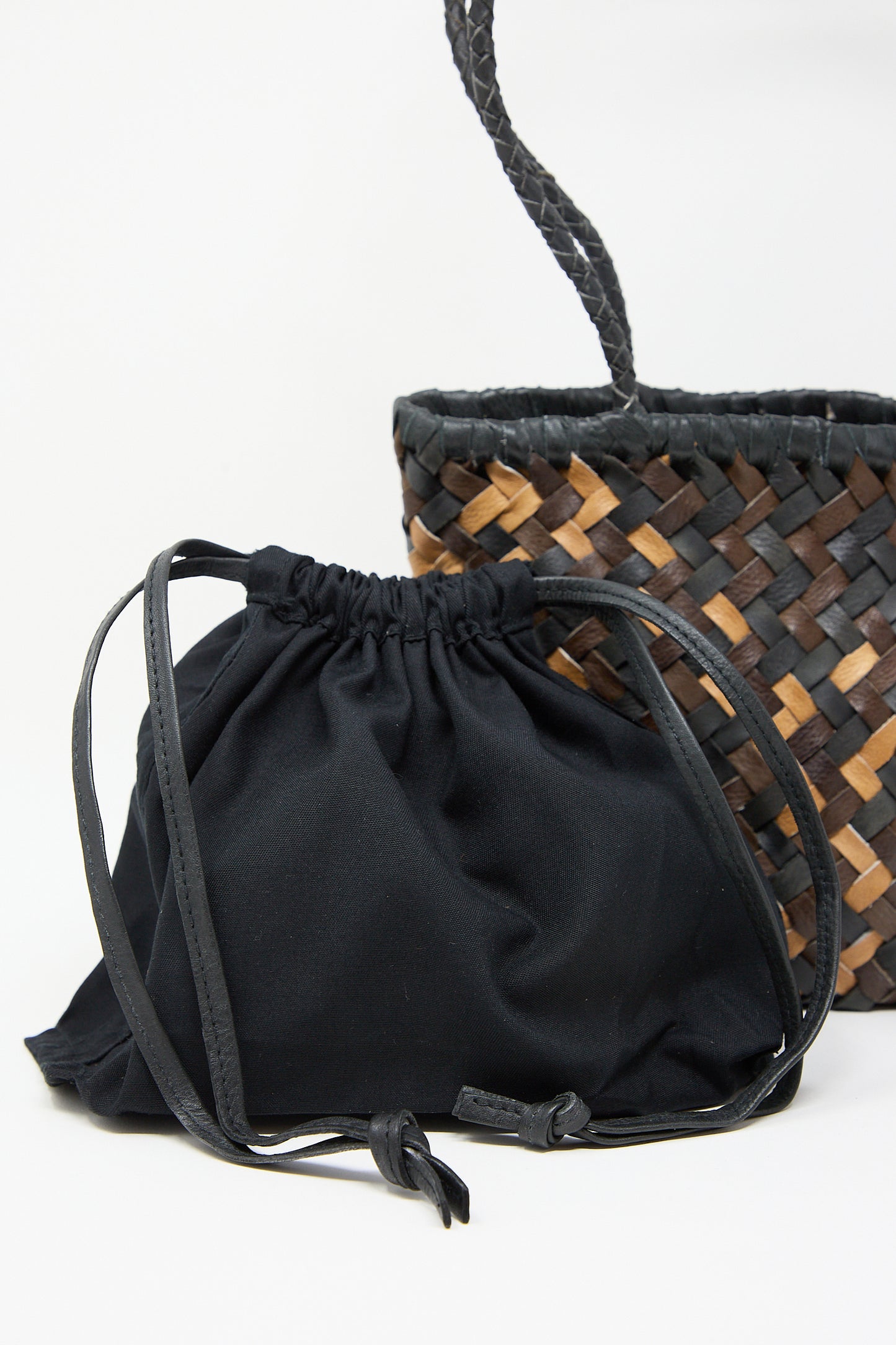 A black Mesh Shoulder Tote in Mix by Ichi Antiquités in front of a woven basket.