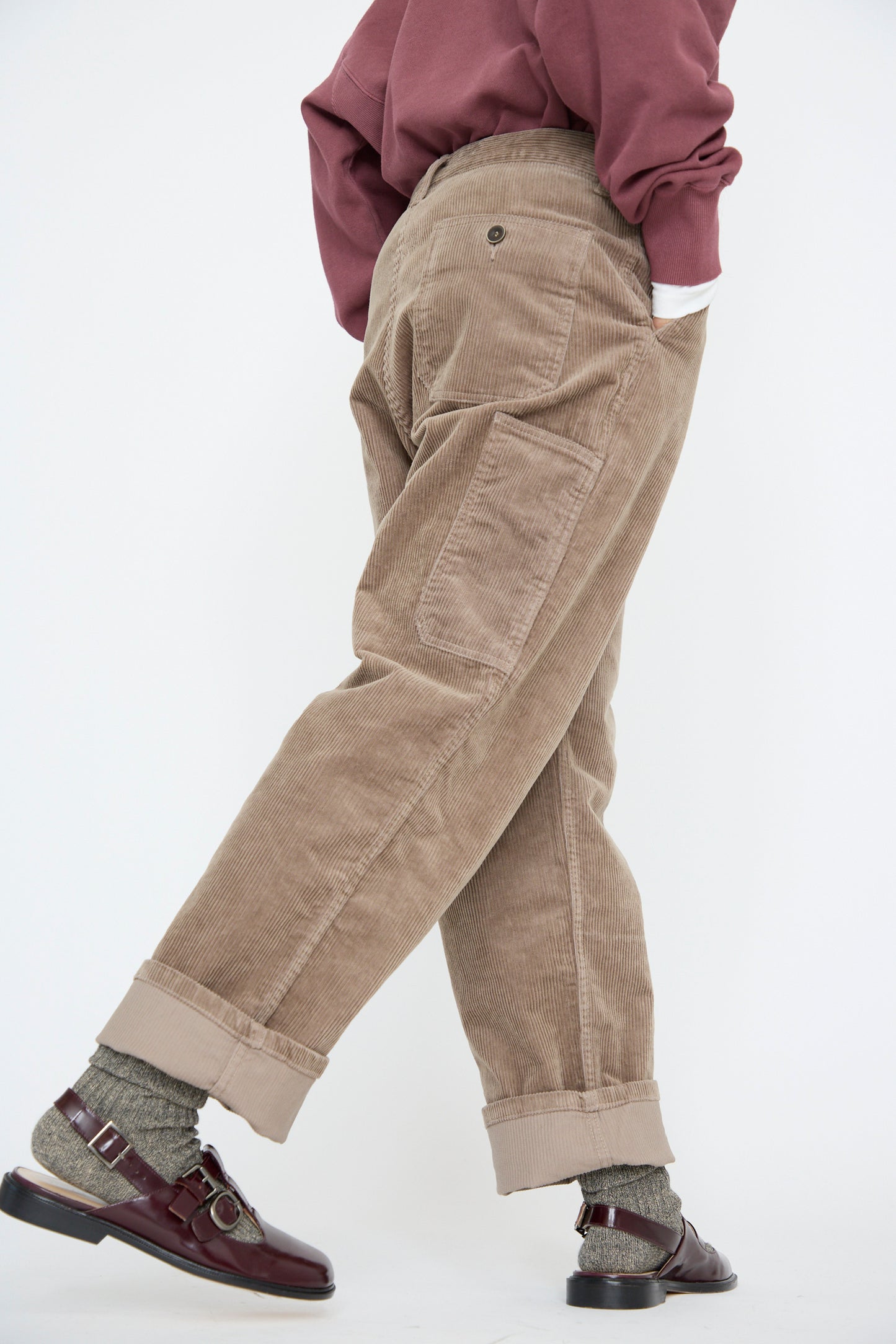 Against a plain white background, a person showcases Ichi Antiquités' Stretch Call Corduroy Pants in Mocha with burgundy shoes and a mauve shirt.