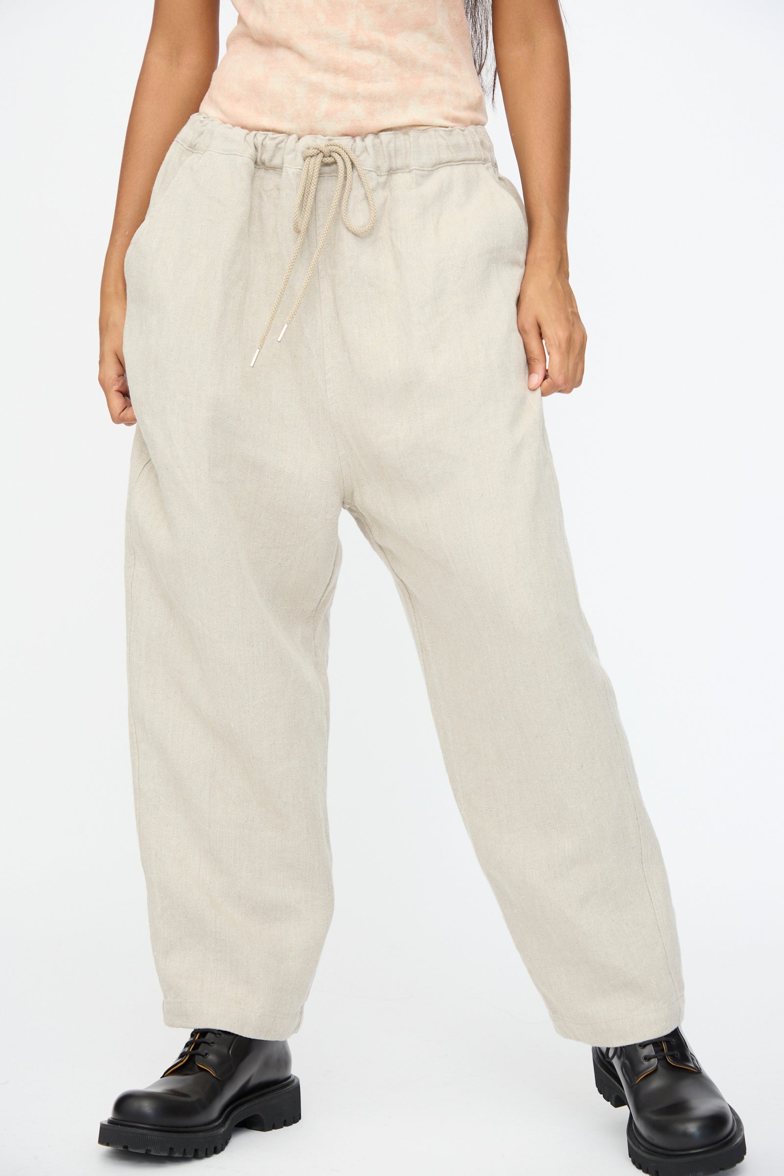 Model wears Ichi Antiquités' Twill Weave Linen Pant in Natural, featuring a wide-leg silhouette and drawstring waist, paired with black boots. Only the lower half is visible against a plain white background.