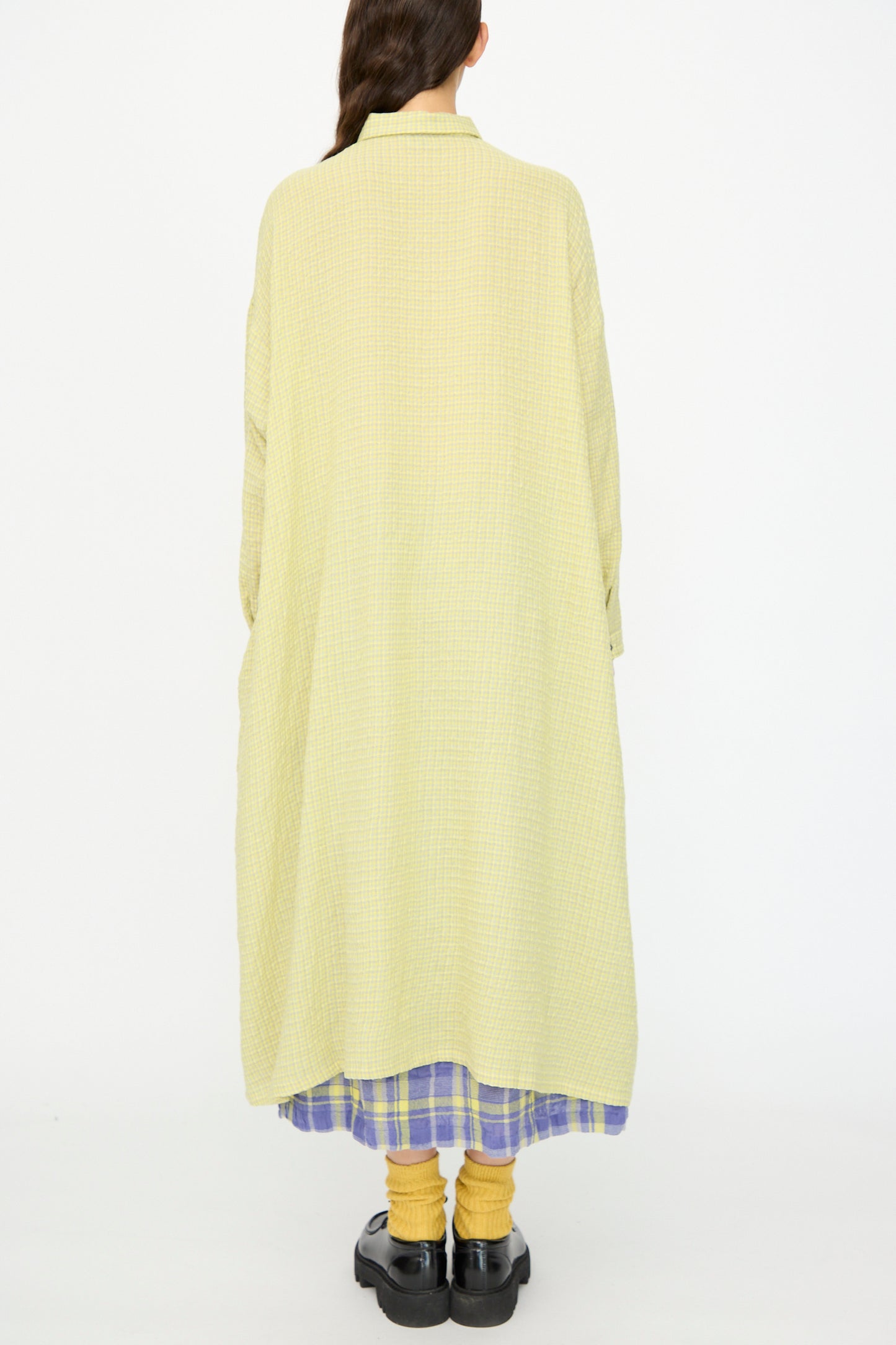 A person stands with their back to the camera, wearing the Ichi Antiquités Wool Cotton Gingham Dress in Yellow and Gray.