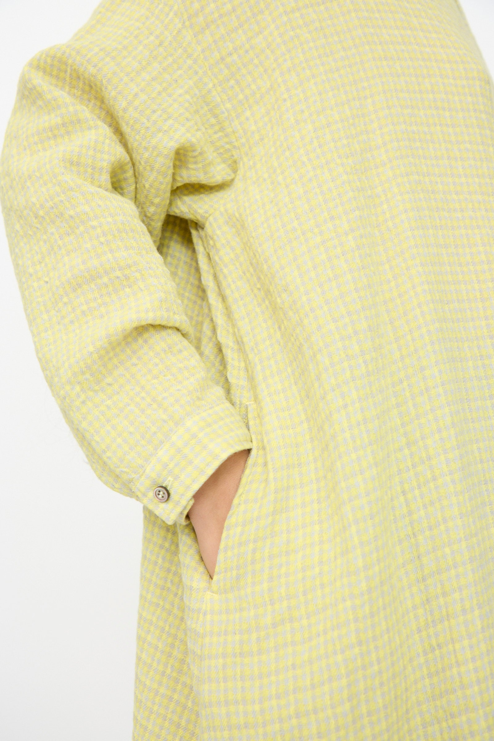 A person wears the Ichi Antiquités Wool Cotton Gingham Dress in Yellow and Gray, featuring an oversized silhouette, long sleeves, and a side pocket.
