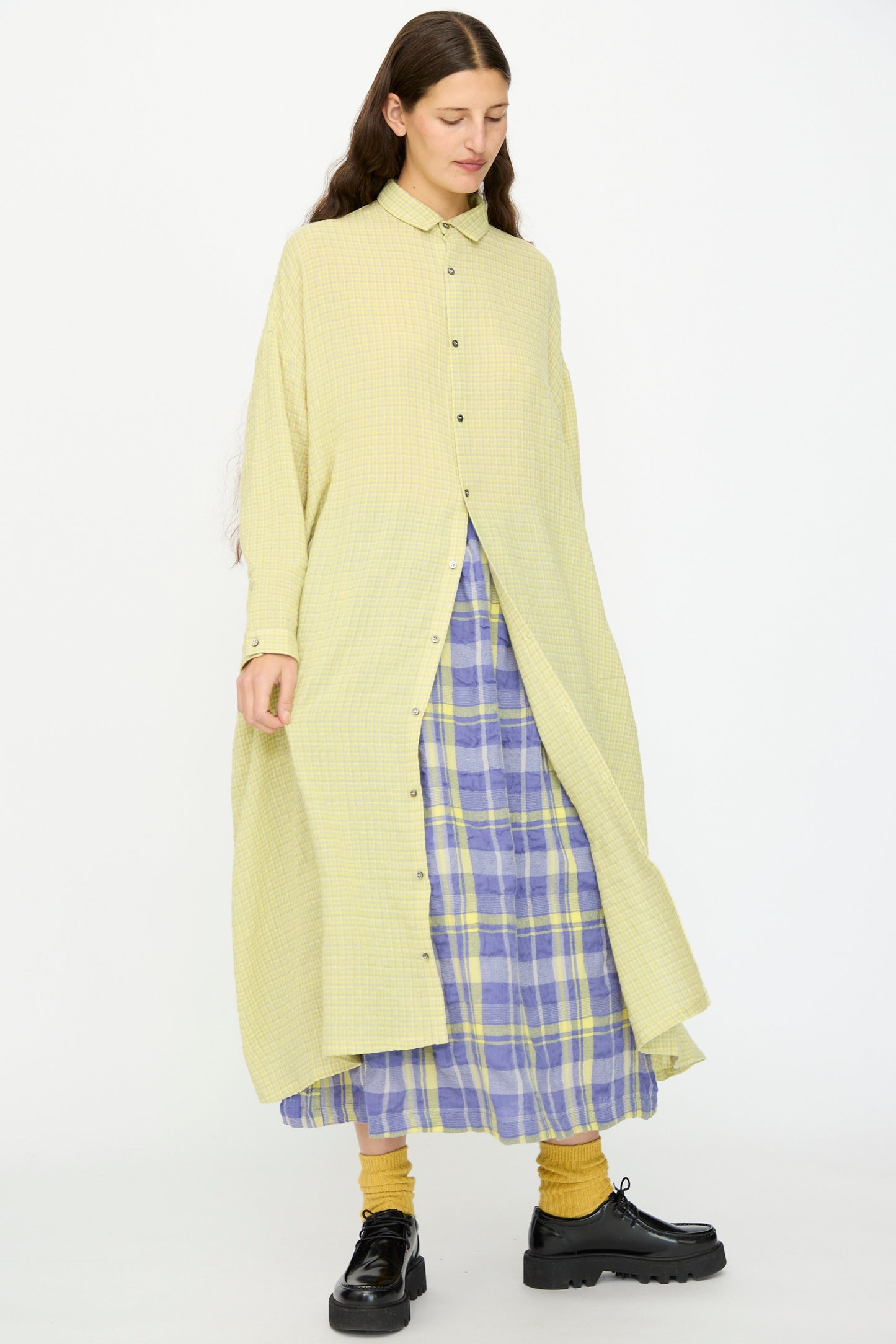 A person wearing the Ichi Antiquités Wool Cotton Gingham Dress in Yellow and Gray with yellow socks and black shoes, standing against a plain background.