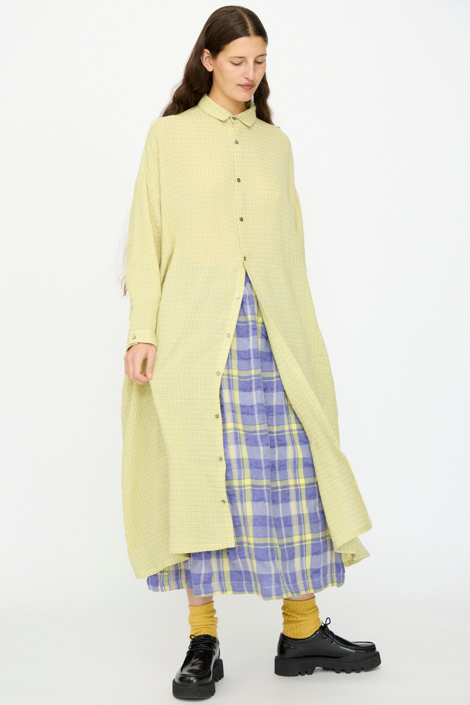 A person wearing the Ichi Antiquités Wool Cotton Gingham Dress in Yellow and Gray with yellow socks and black shoes, standing against a plain background.