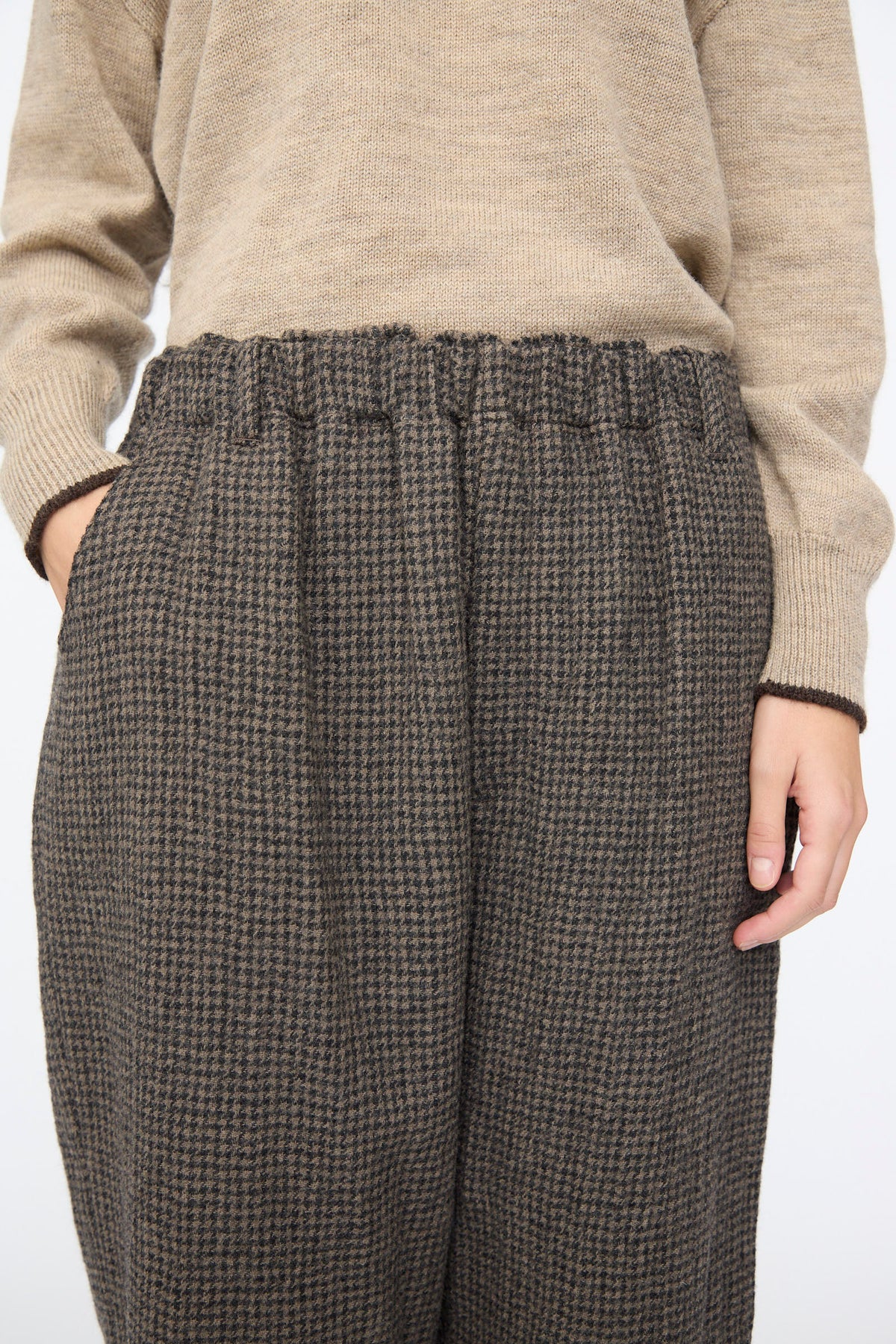 Relaxed-fit brown Wool Gauze Houndstooth Pants in Mocha with an elastic waist worn with a tan sweater.