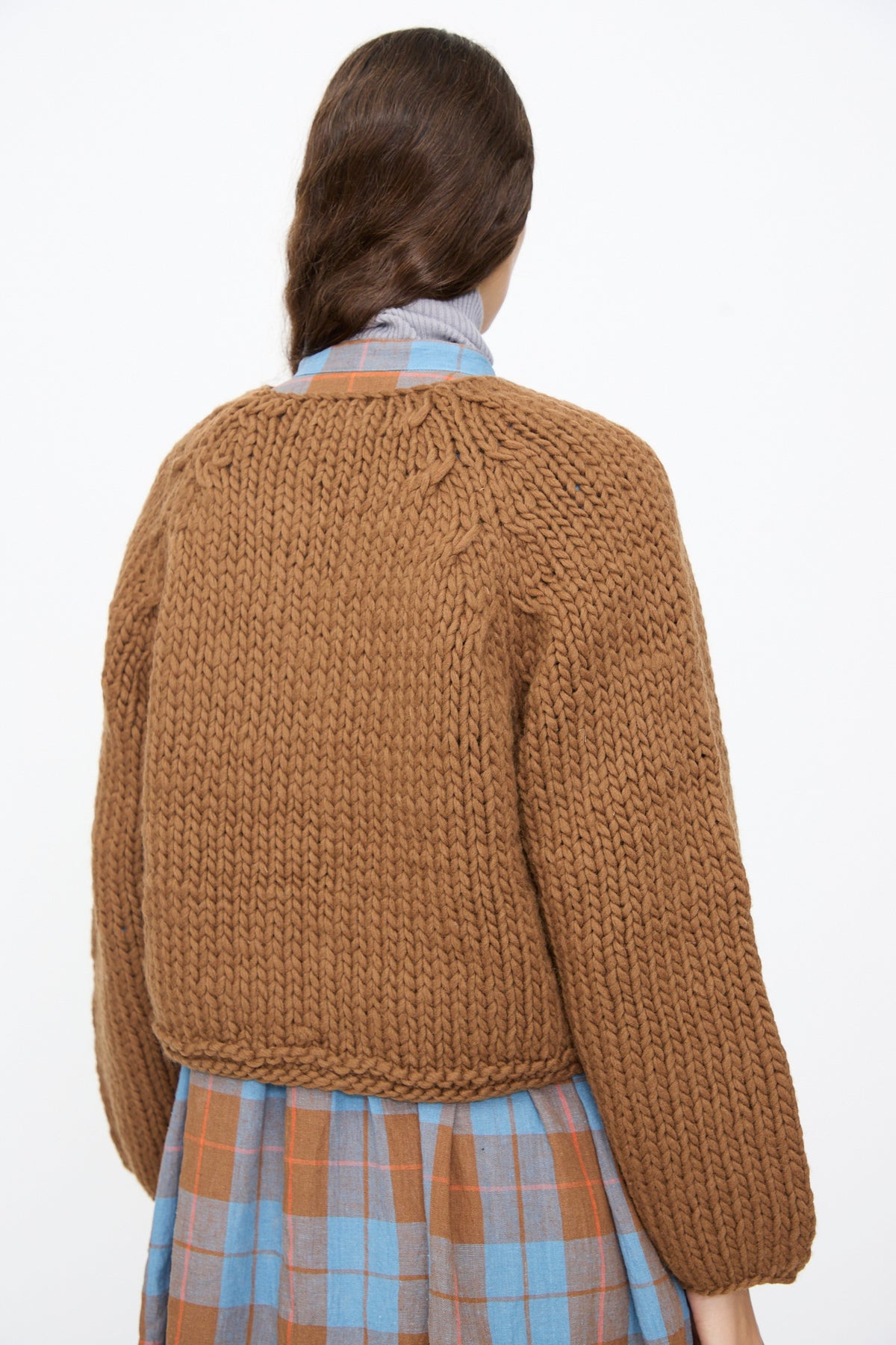 Back view of a cropped, hand-knit Ichi Antiquités Wool Hand Knit Pullover in Brown layered over a plaid shirt.