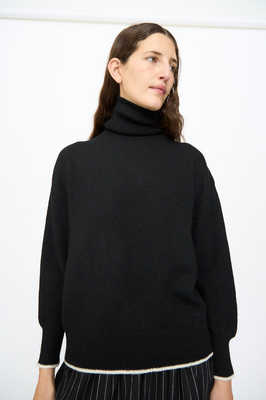 Ichi Antiquités Wool Pullover in Black and White, a black wool turtleneck sweater with white trim at the cuffs and hem.