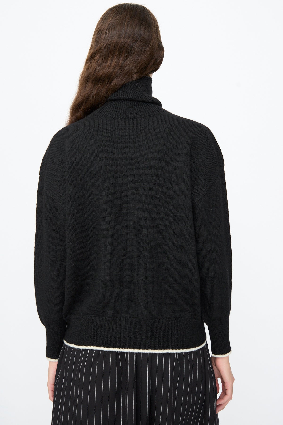 Back view of the Ichi Antiquités Wool Pullover in Black and White, a black wool turtleneck with a white stripe along the bottom hem.