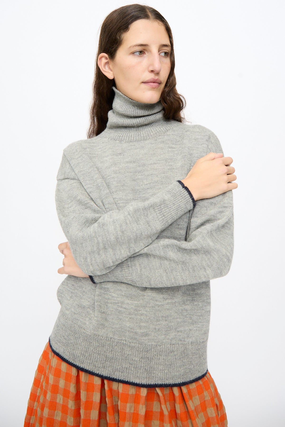 Ichi Antiquités Wool Pullover in Gray and Navy, featuring a gray wool turtleneck with navy blue trim, layered over a burnt orange and beige checkered skirt.