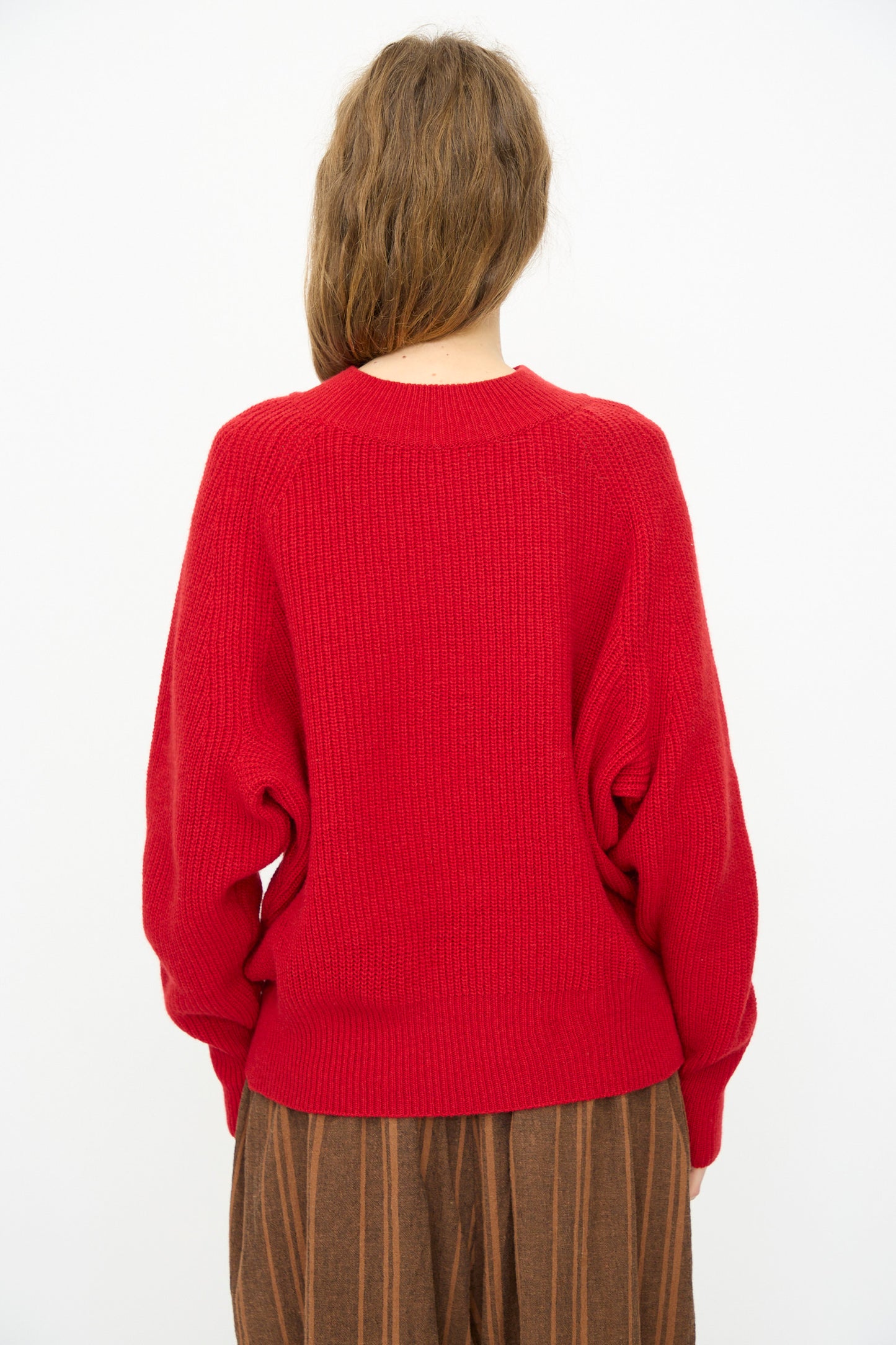 A person with long brown hair wears the Ichi Antiquités Wool Rib Knit Pullover in Red, shown from the back against a plain white background.