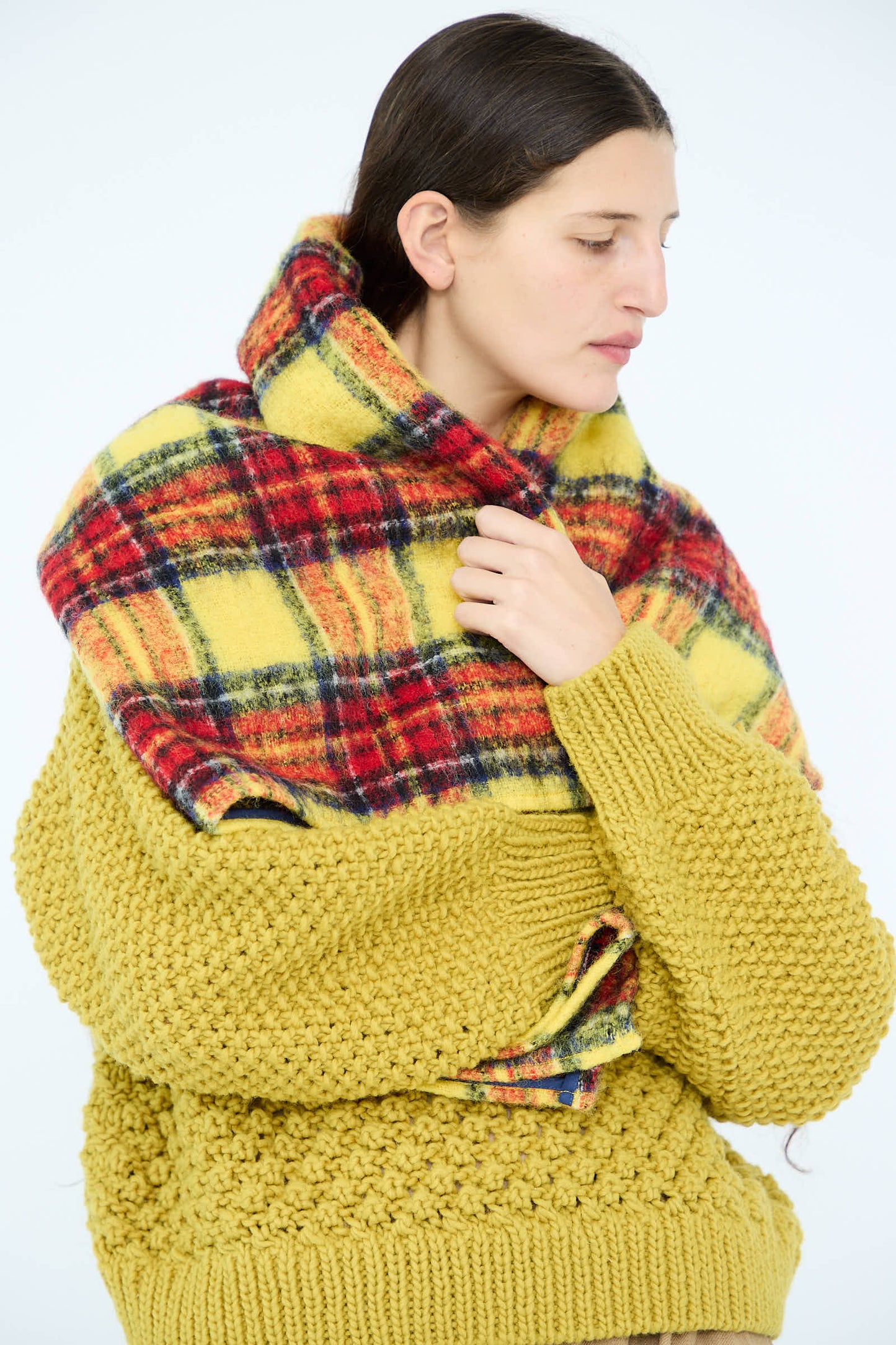 A person wearing the Ichi Antiquités Wool Tartan Shaggy Stole in Yellow glances sideways.