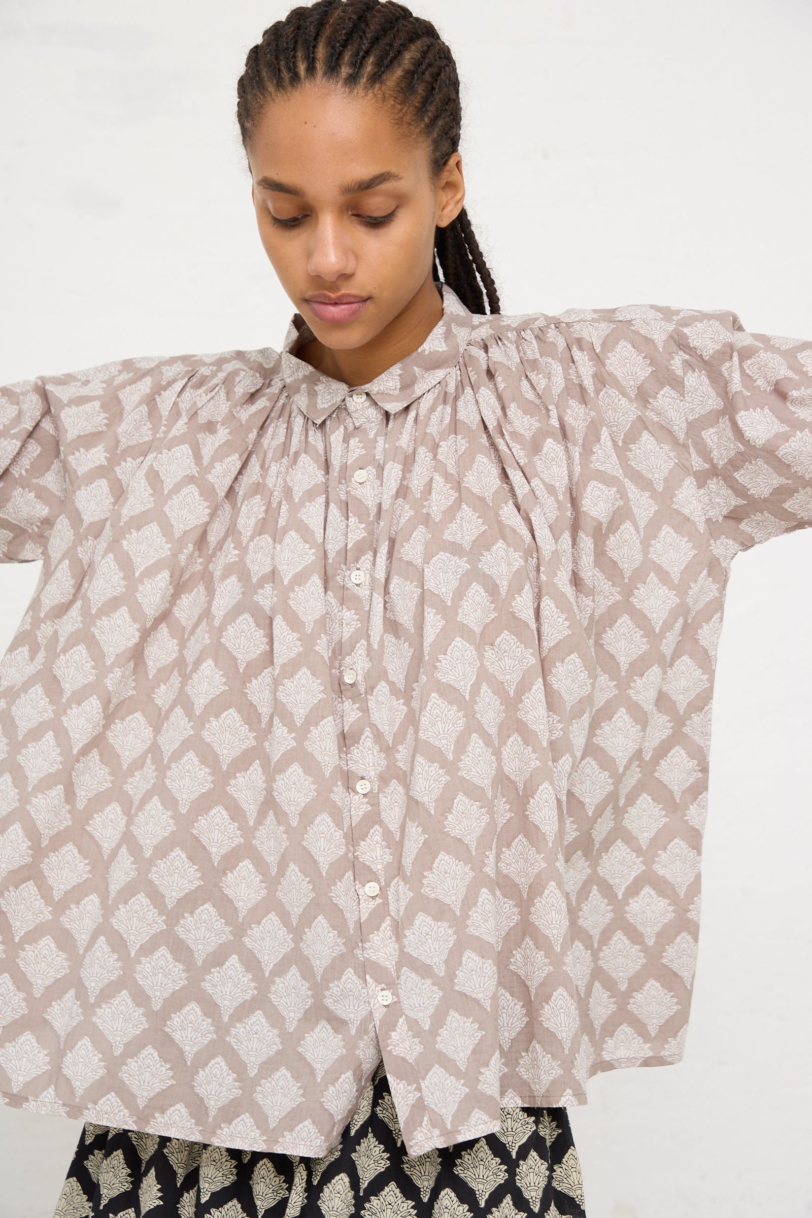 A woman in an Ichi Antiquités Woven Cotton Indian Block Print Shirt in Beige with puff sleeves standing against a white background.