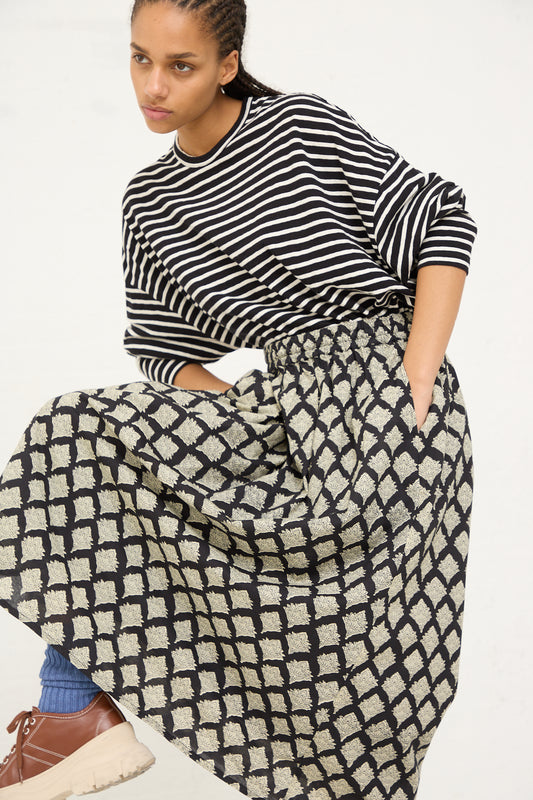 Woman modeling a striped top and an Ichi Antiquités woven cotton Indian block print skirt in black, with a dynamic pose showing movement in the fabric.