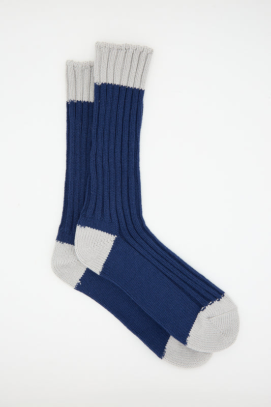 A pair of Ichi Antiquités Cotton Rib Sock in Navy with light grey toe, heel, and top cuff areas, made from organic cotton and displayed on a plain white background.