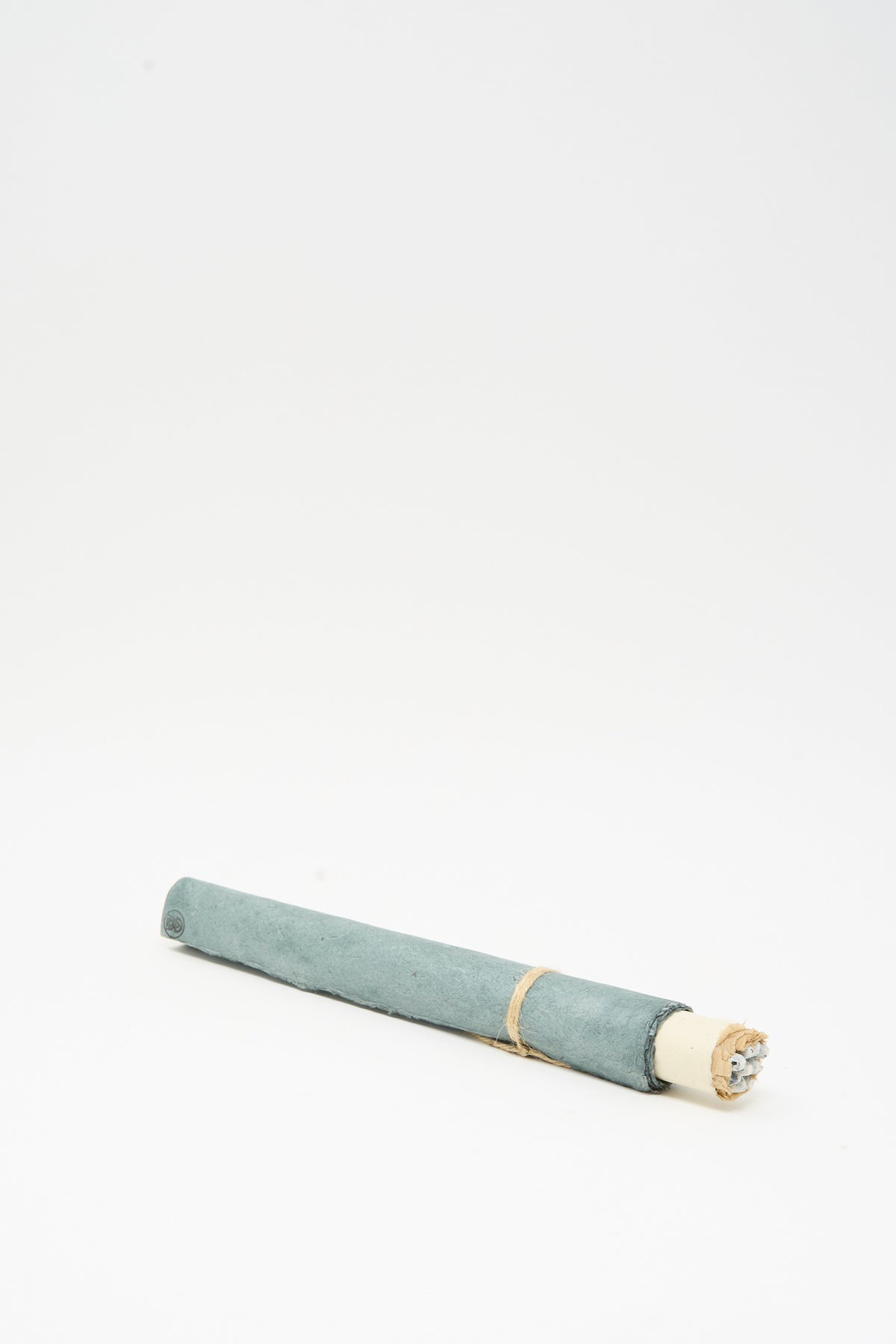 A blue-grey paper scroll of handmade Incausa Copal Incense Scroll sticks tied with twine.