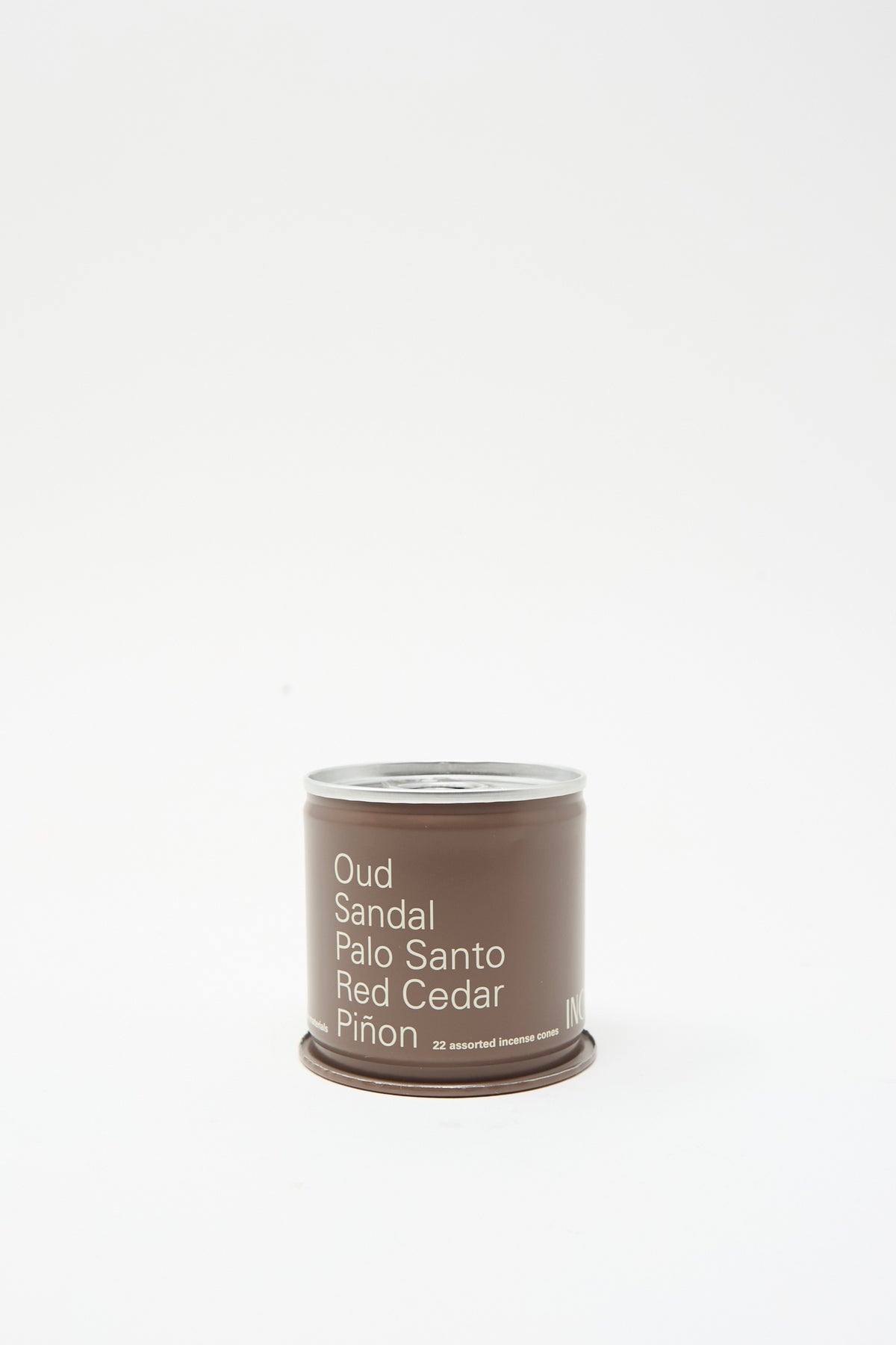 A brown cylindrical tin of Incausa Discovery Incense Cones labeled with the scents Oud, Sandal, Palo Santo, Red Cedar, and Piñon.