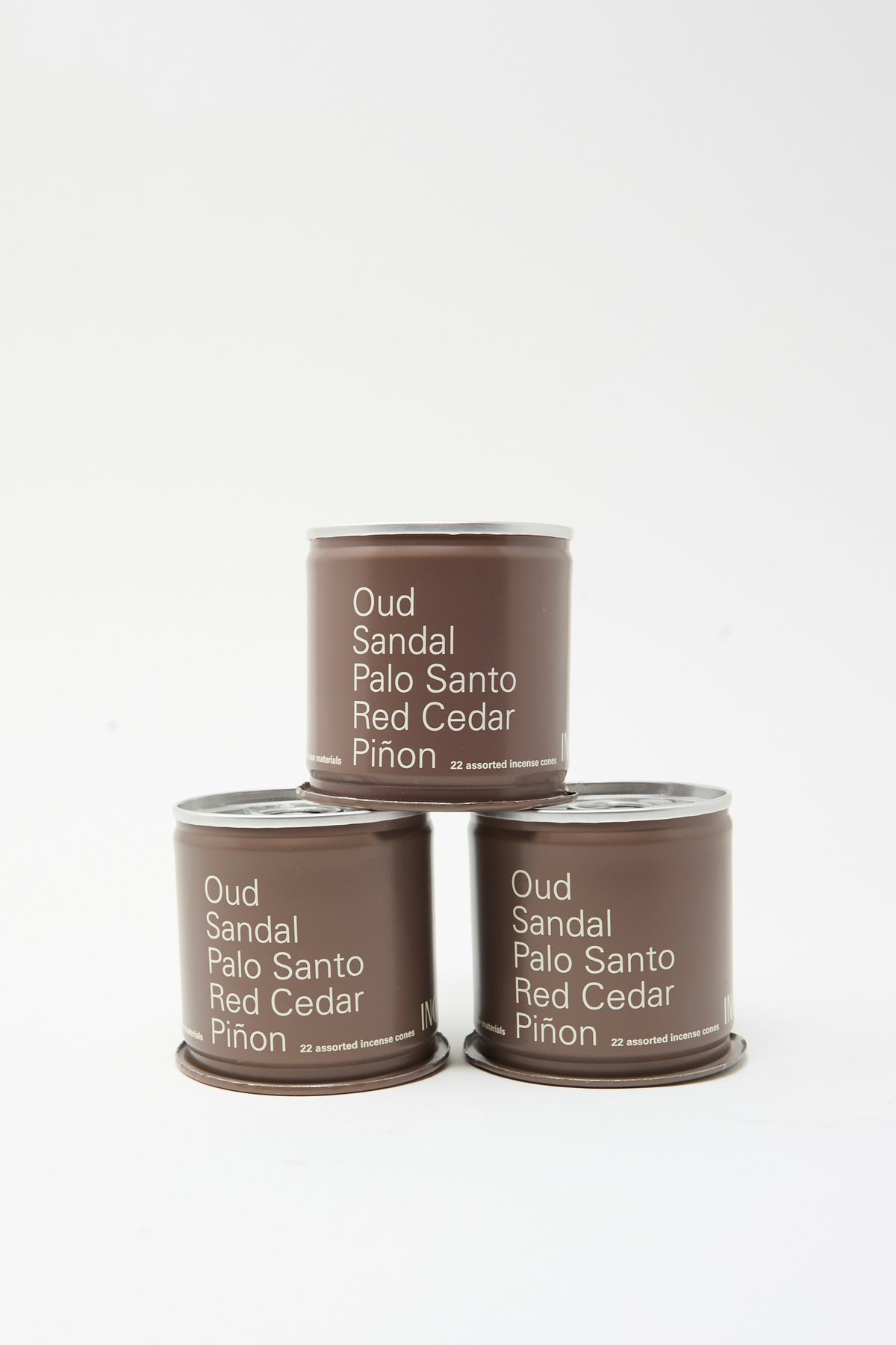 Three brown metal tins of Incausa Discovery Incense Cones stacked in a pyramid, each labeled with the names of five scents.