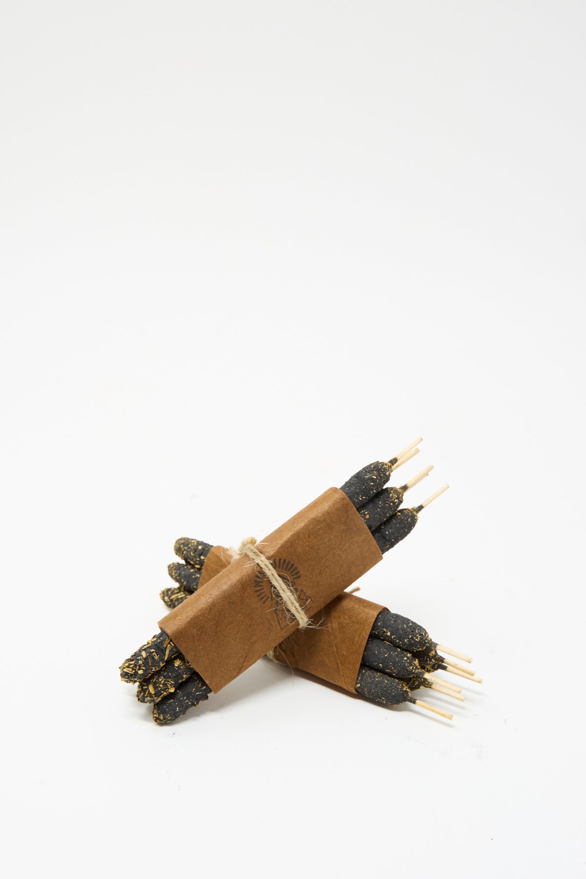 Two bundles of Half Dozen Incense Bundles in Palo Santo wrapped in brown paper and tied with twine.