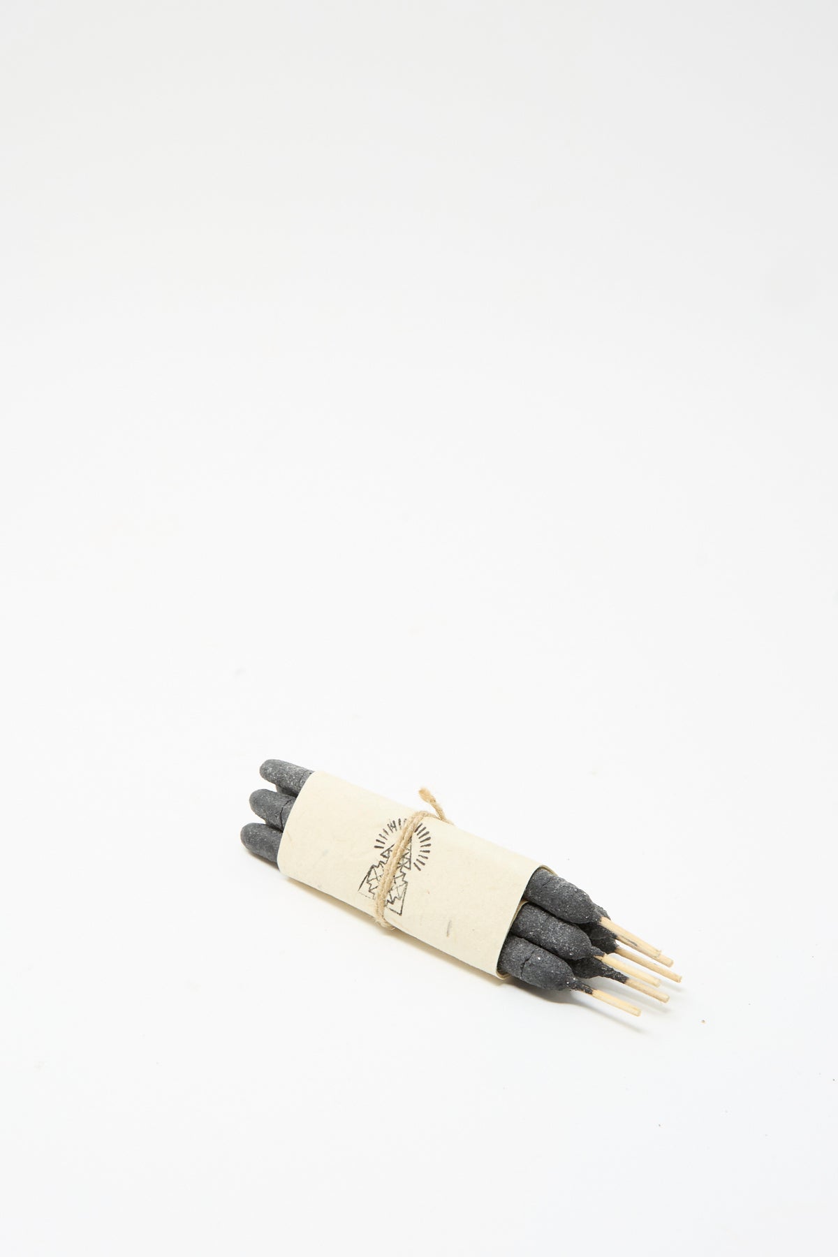 A bundle of six dark pure breu Incausa Half Dozen Incense Bundles in Pure Breu secured with a paper band featuring a line-art illustration of mountains.