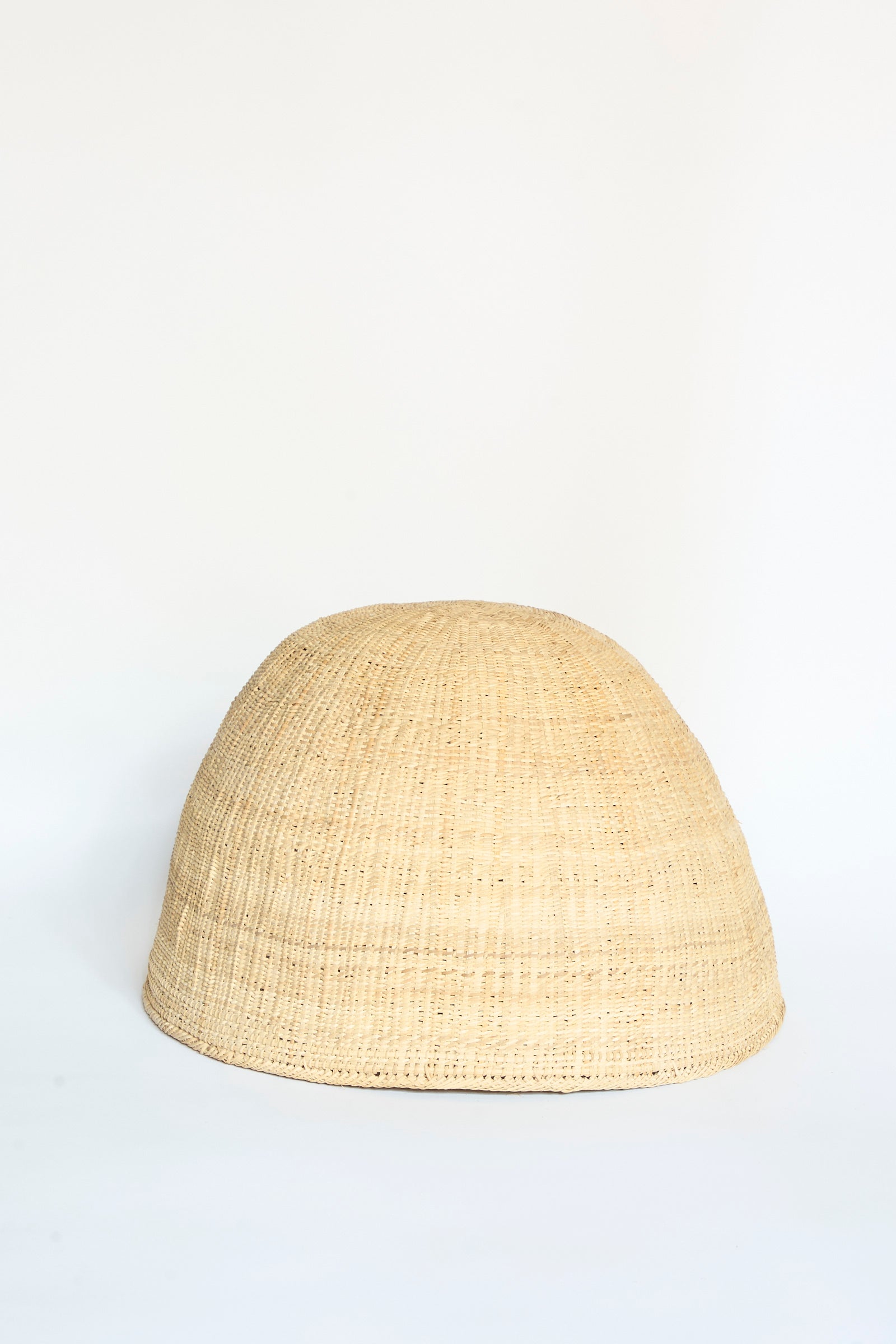 The Yanomami Wii Basket Large in Natural by Incausa, a dome-shaped handwoven basket with a tight weave crafted from Titica vine, sits on a plain white background.