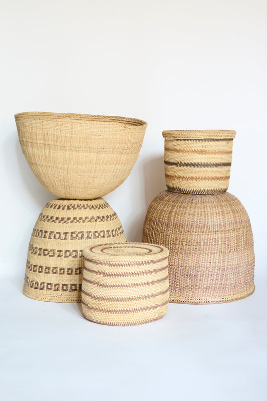 Four woven baskets of varying sizes and patterns, including the beautifully crafted Yanomami Wii Basket Large in Natural by Incausa, are displayed against a plain white background.