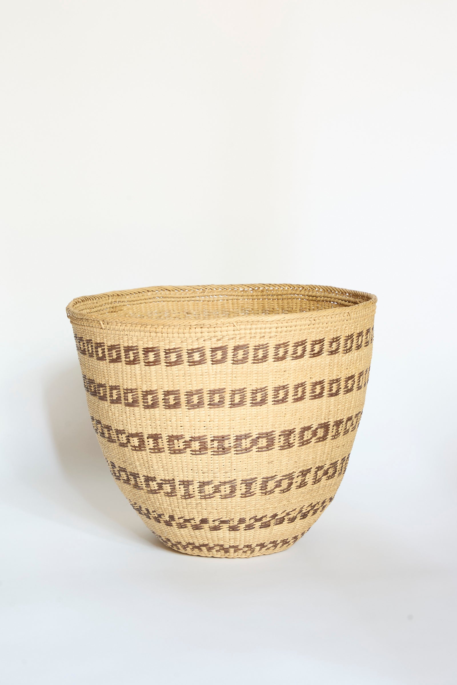 The Yanomami Wii Basket Large in Natural with Squares by Incausa is a handwoven storage basket crafted from Titica vine, featuring geometric brown square patterns arranged in horizontal rows on a light tan background, inspired by traditional Yanomami designs from the Amazon and displayed against a plain white surface.